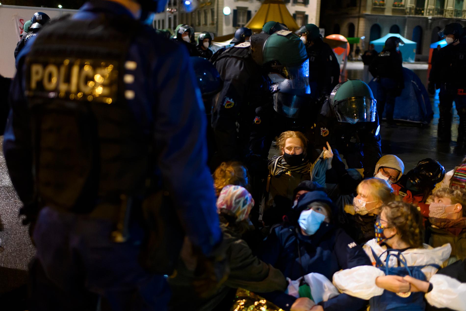 Polis för bort deltagare i klimatprotesten i närheten av den schweiziska parlamentsbyggnaden i Bern.