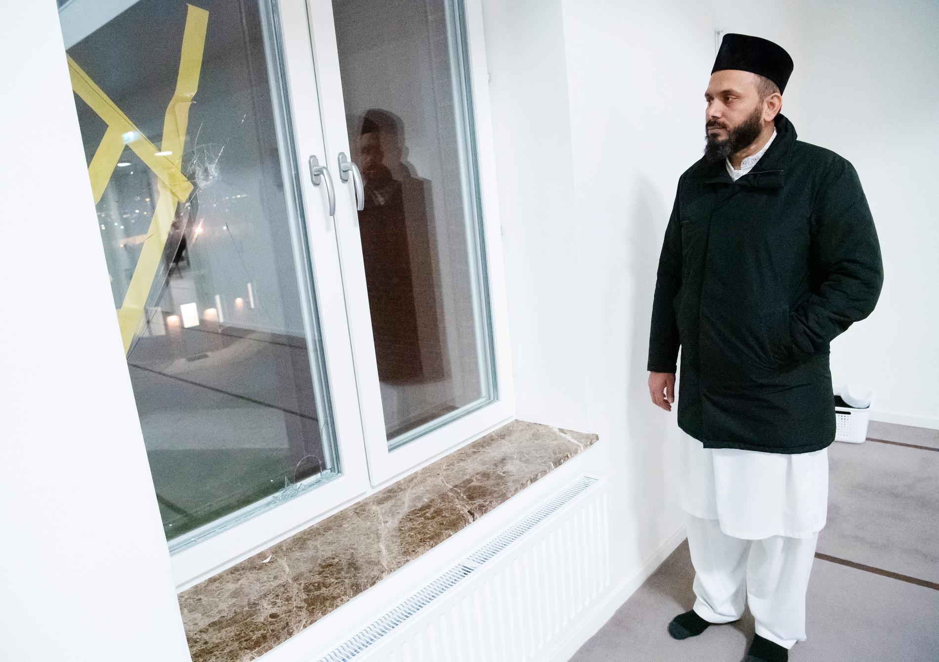 Imam Rizwan Afzal vid skotthålet i ett fönster.