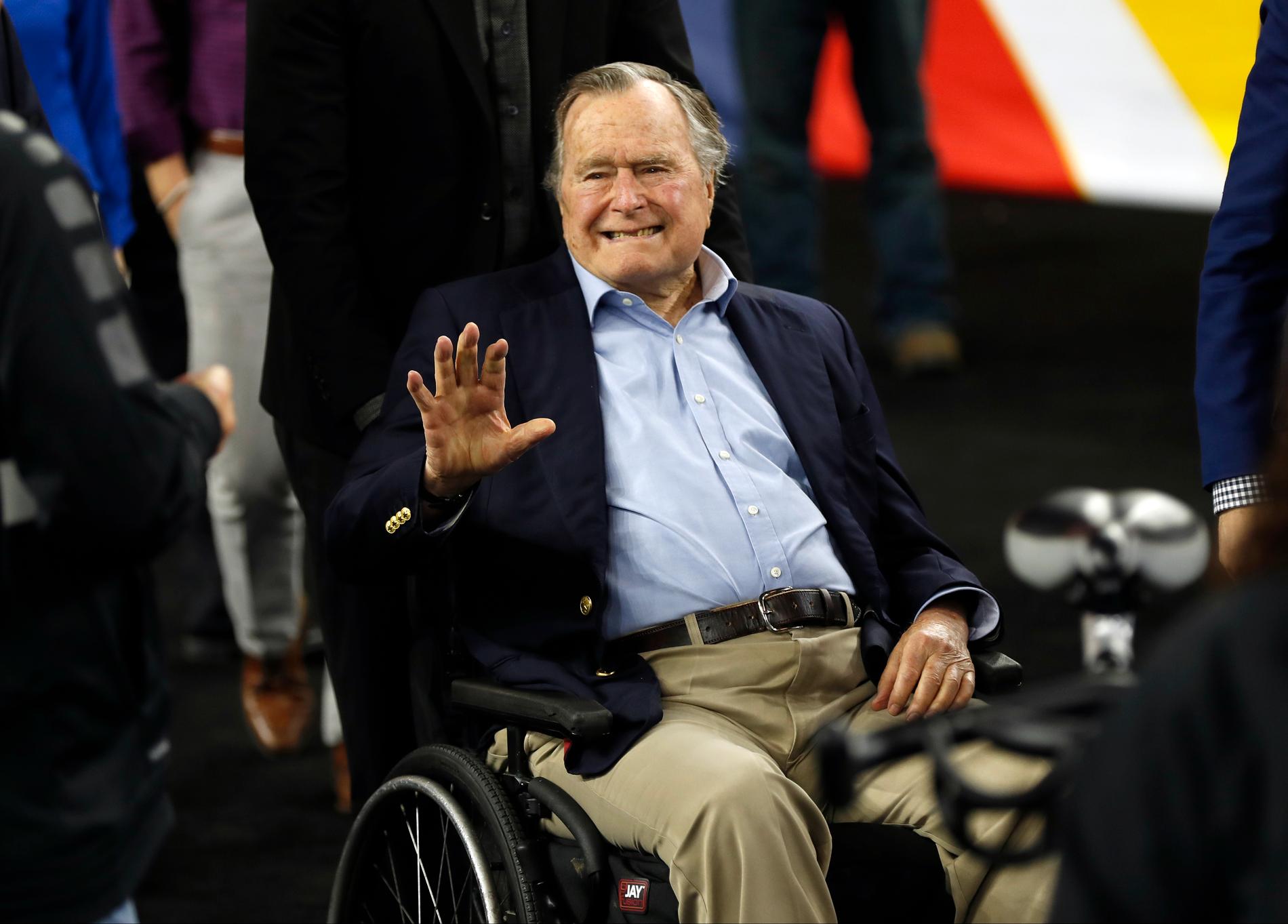 Expresidenten George H W Bush vinkar när han anländer till en basketmatch i Houston Texas 1916.