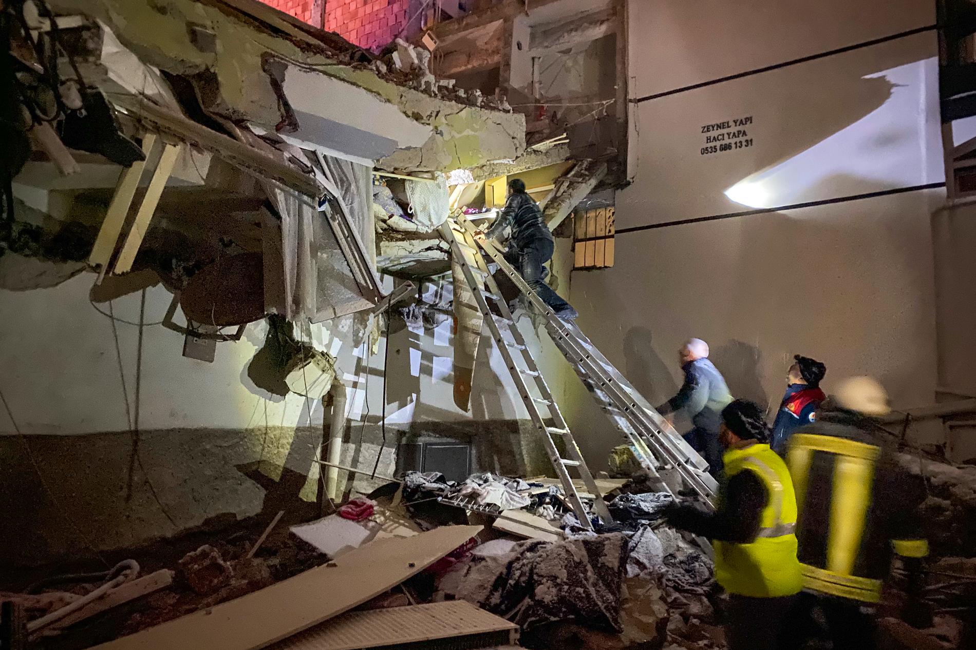 Ett räddningsteam försöker nå boende som är fast i en byggnad som kollapsat i Adana, Turkiet. 