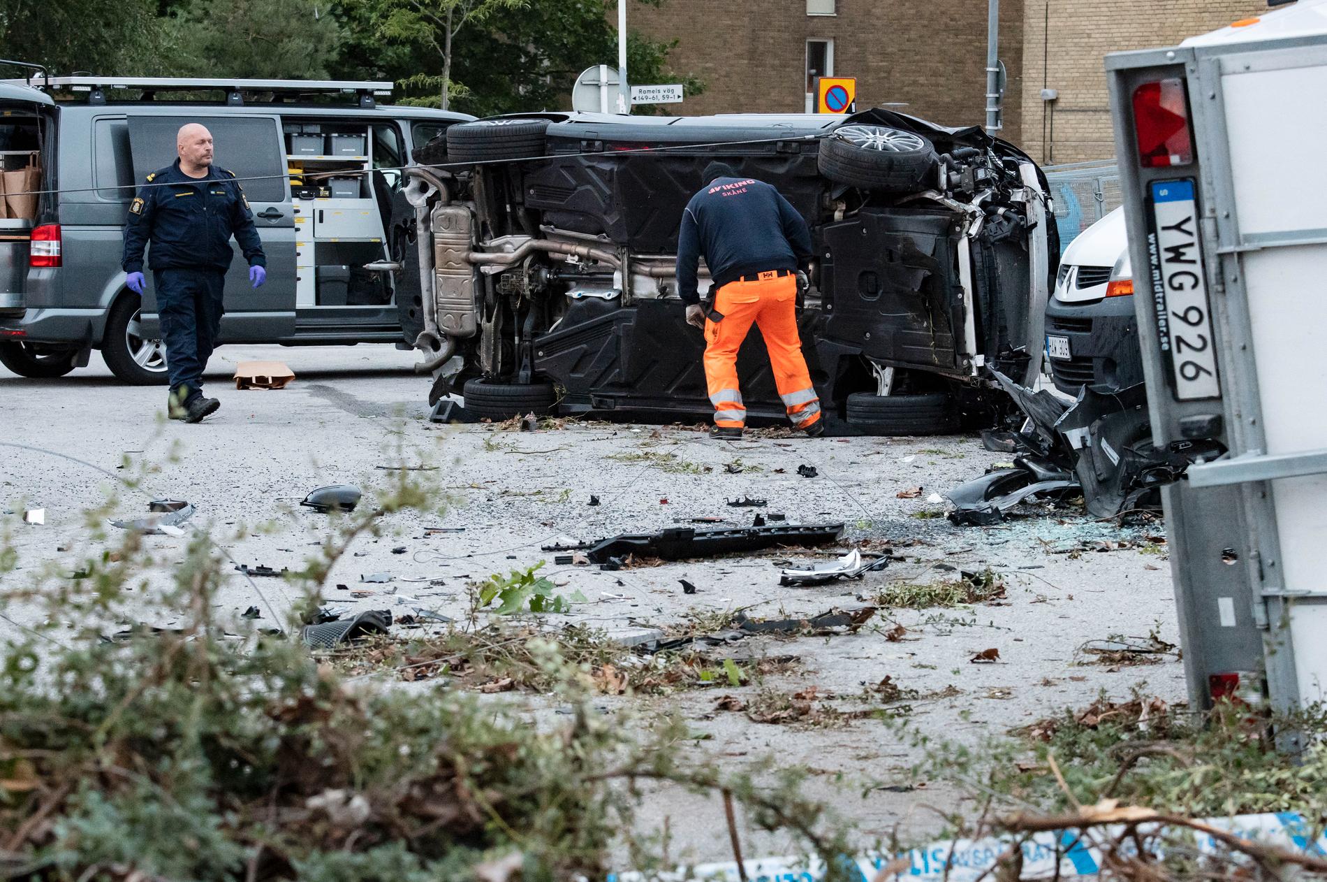 En personbil voltade in på en mack i Rosengård och krockade med ett antal släpvagnar under natten. Vid bilen fanns en skottskadad man.