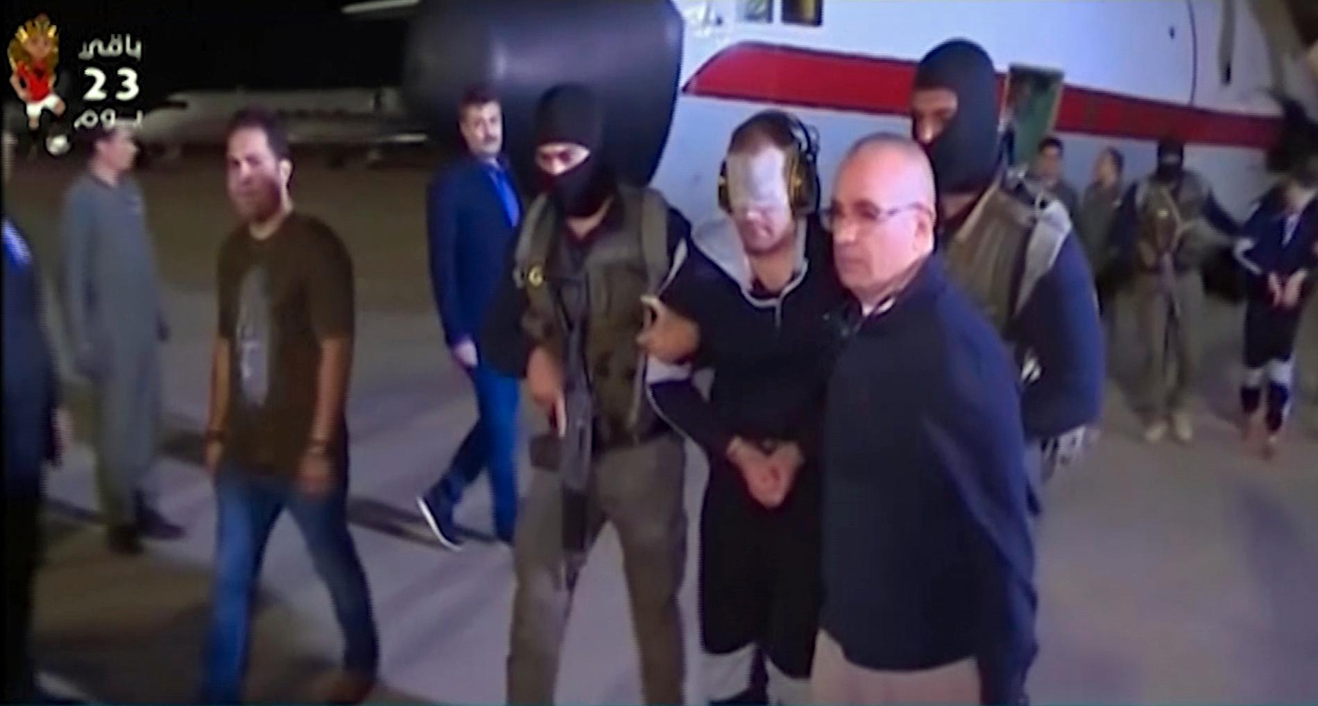 Hisham al-Ashmawy (med övertejpade ögon i mitten) i samband med utlämnandet från Libyen 2019. Bild från egyptisk tv.