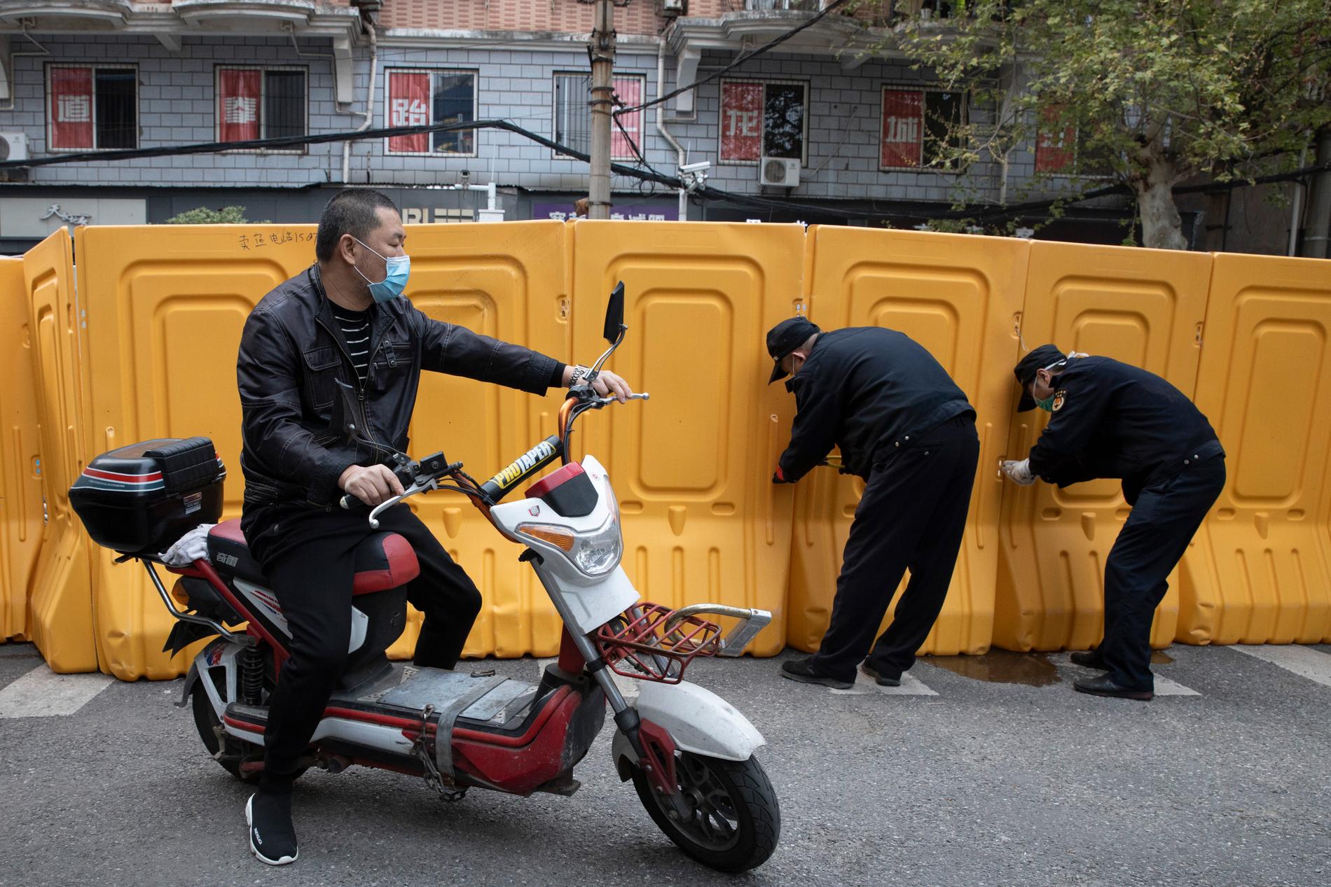 Plastbarriärer, som sattes upp för att skilja av bostadsområden från varandra under virusutbrottet, rivs i den centralkinesiska staden Wuhan.