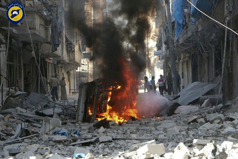 Människor går runt bland förödelsen i Aleppo efter bombningar utförda av den syriska regimens helikoptrar på tisdagen.