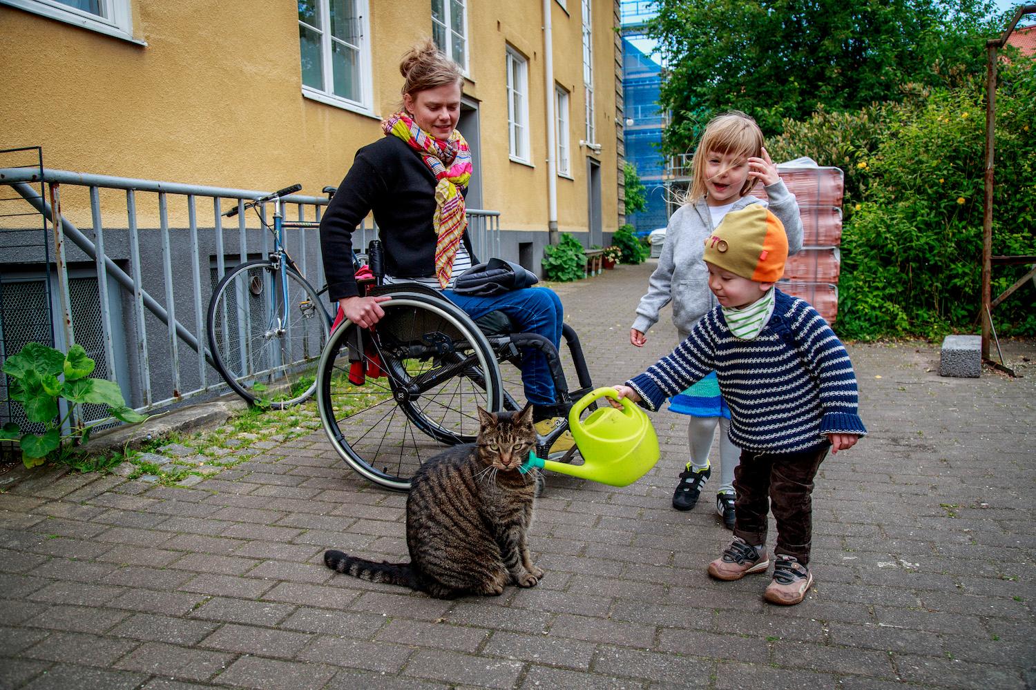 Otto, 1,5, försöker "vattna" katten på gården i Malmö. När Anna Oredsson, 34, blev gravid med Maja, 4, fanns ingen kunskap i vården om  ryggmärgsskada, graviditet och förlossning