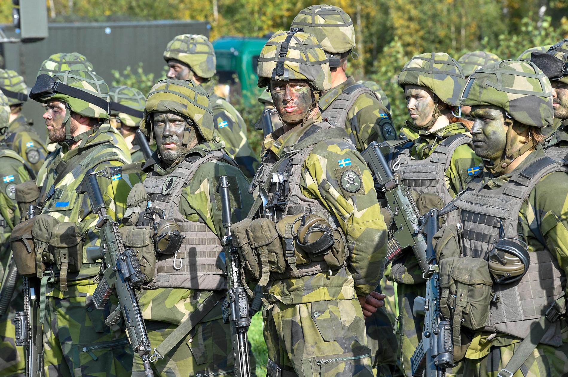 Soldater med kamouflagemålning under försvarsövningen Aurora 17. Arkivbild.