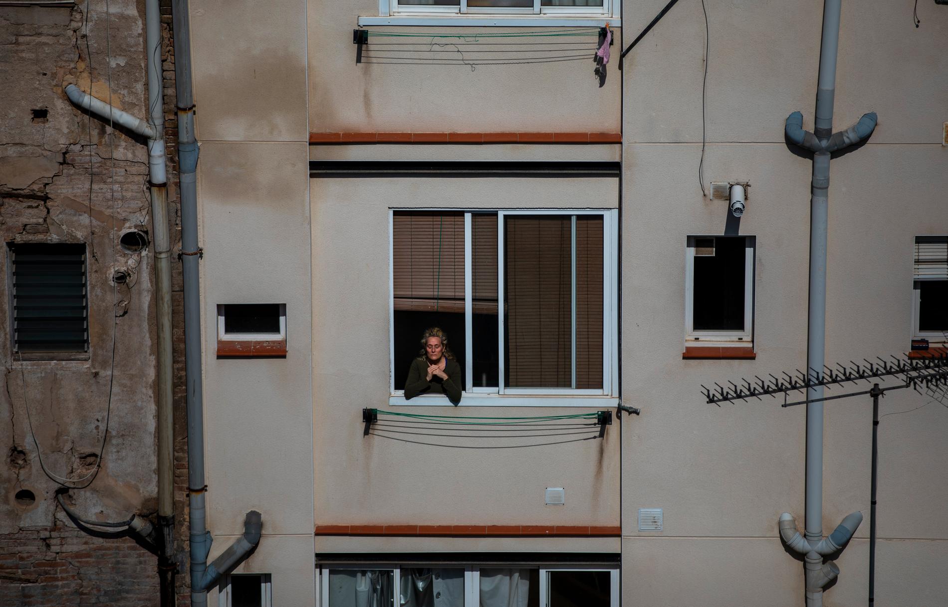 En kvinna i ett fönster i Barcelona i Spanien.
