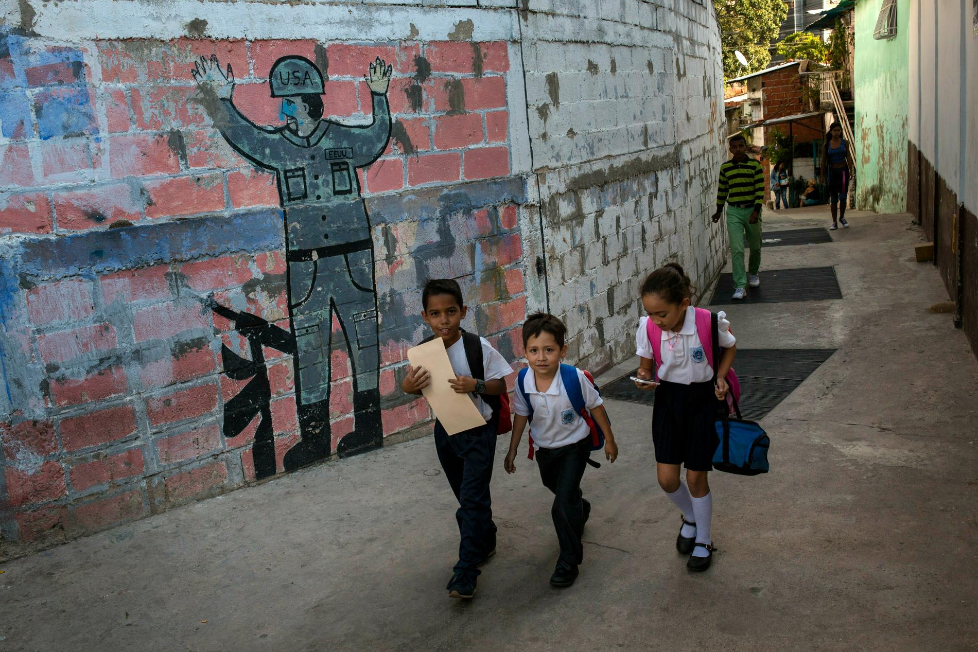 Skolbarn i Caracas går förbi en målning föreställande en kapitulerande soldat från USA. Maduros anhängare i Venezuela beskriver försöken till maktskifte som en komplott från USA.