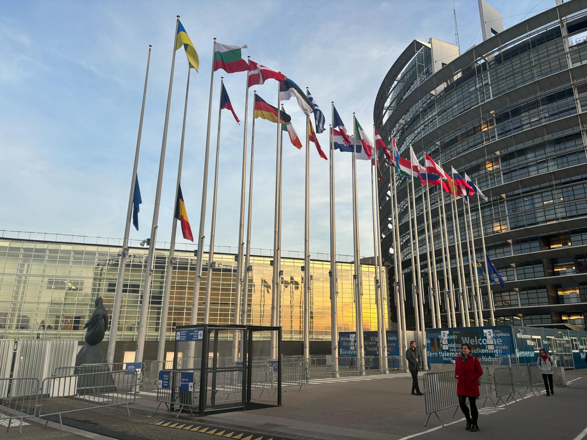 Sveriges, Belgiens och EU:s flagga på halvstång utanför EU-pralamentet.
