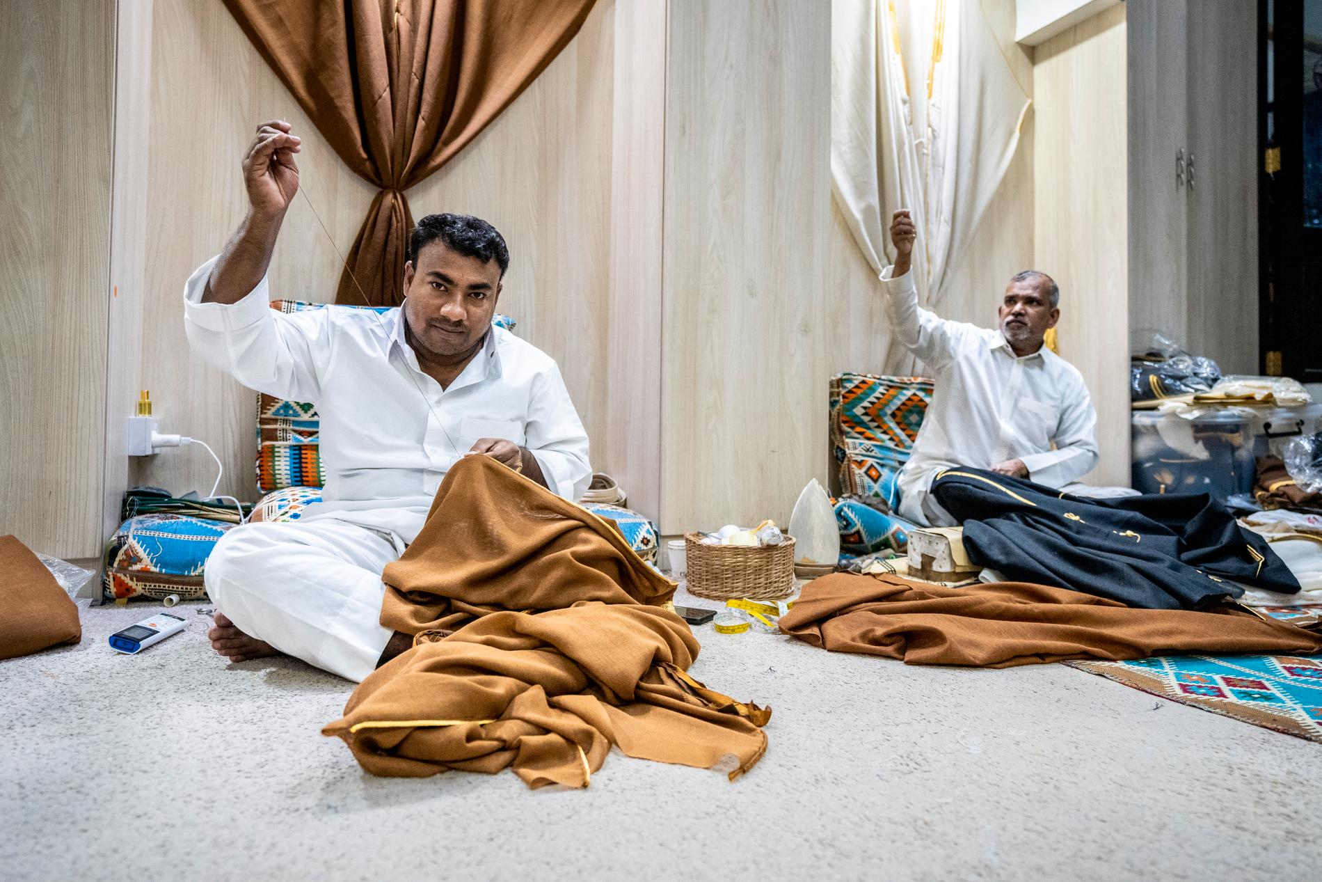 Ariful, 34 och Refiq, 61, båda från Bangladesh, syr kläder på marknaden Souq Waqif i Doha den den 22 november 2022.