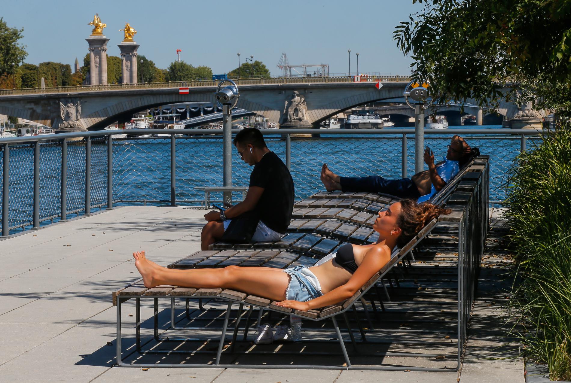 En solbadare vid floden Seine i centrala Paris.