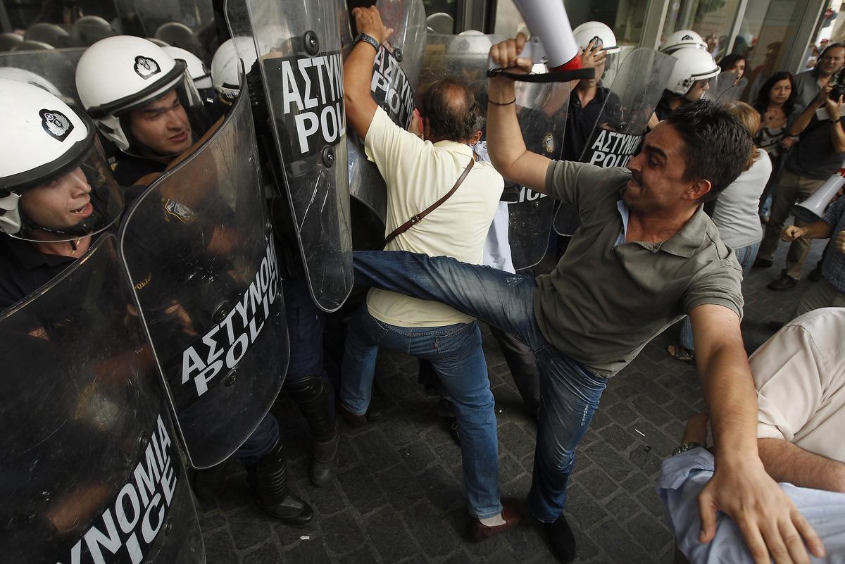 VRÅLAR UT SIN ILSKA  En anställd på finansministeriet i Grekland sparkade mot en polisman när grekerna återigen protesterade mot regeringens nedskärningar i förra veckan. Besparingarna görs för att landet ska möta lånekraven av euroländerna i Europa.