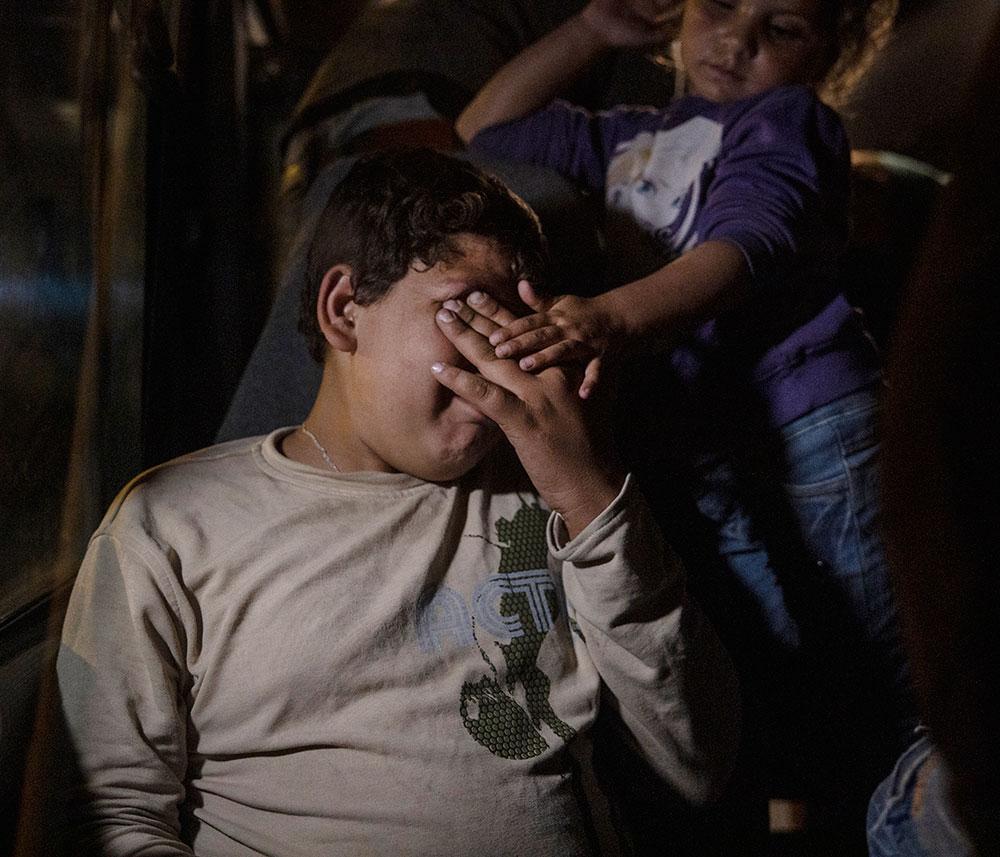 Ahmed, 13 förlorade sin mamma när Turkiet bombade deras hem. Nu sitter han på en buss och väntar på att få en sovplats i flyktinglägret. 