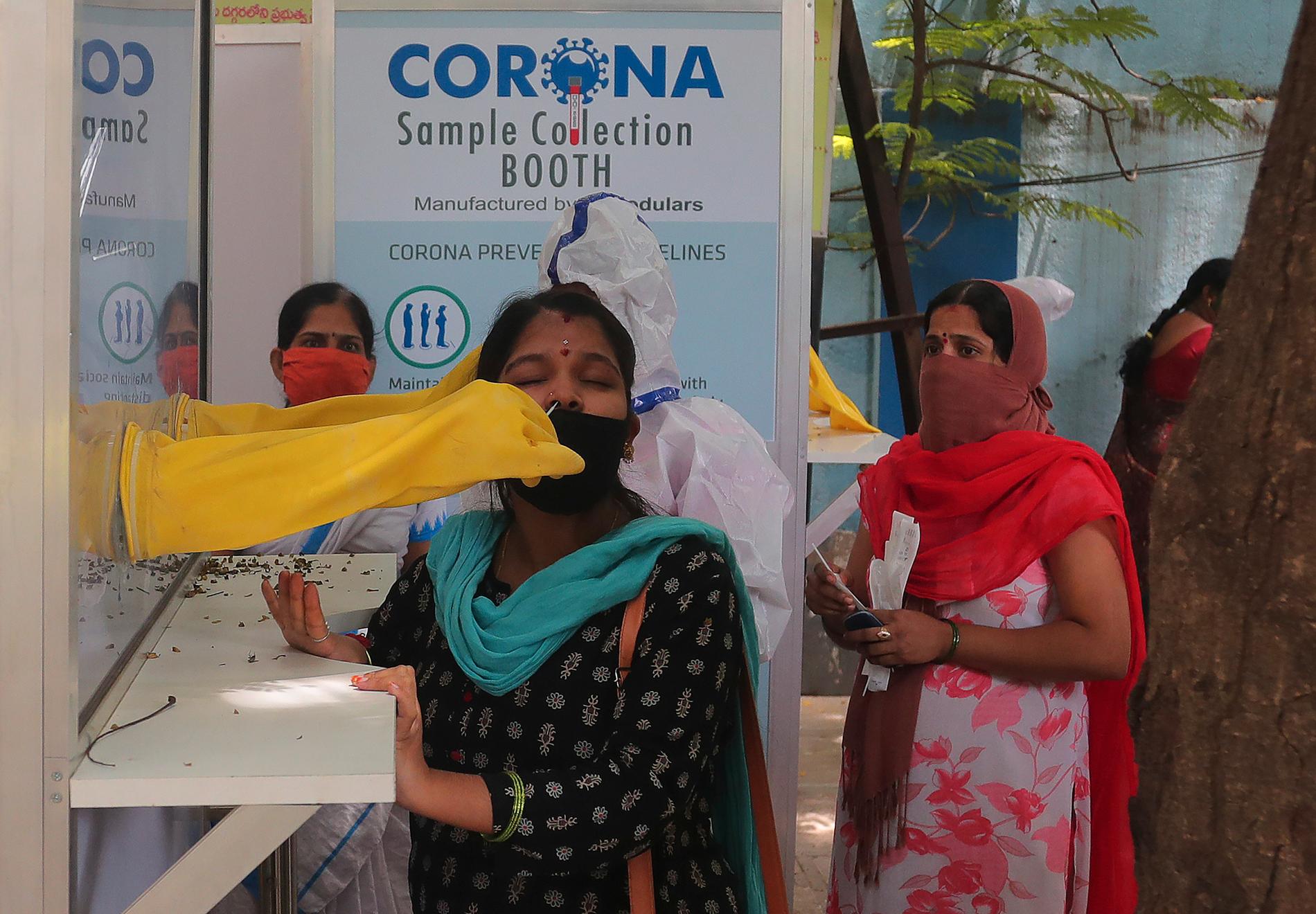 En vårdanställd tar ett test för covid-19 på en kvinna i Hyderabad, Indien, den 28 augusti.