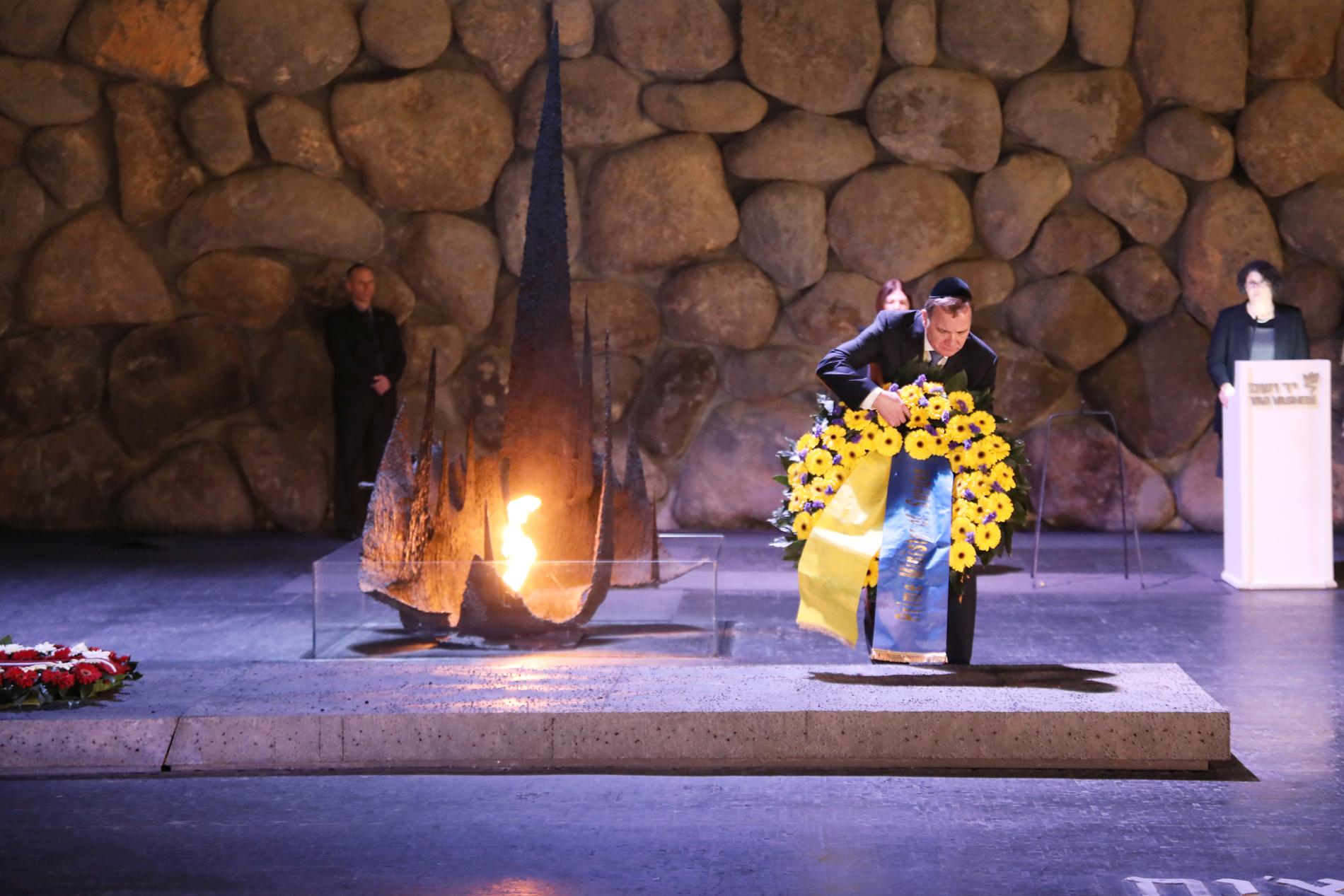 Löfven lägger ner en blomkrans för att hedra nazismens offer. 