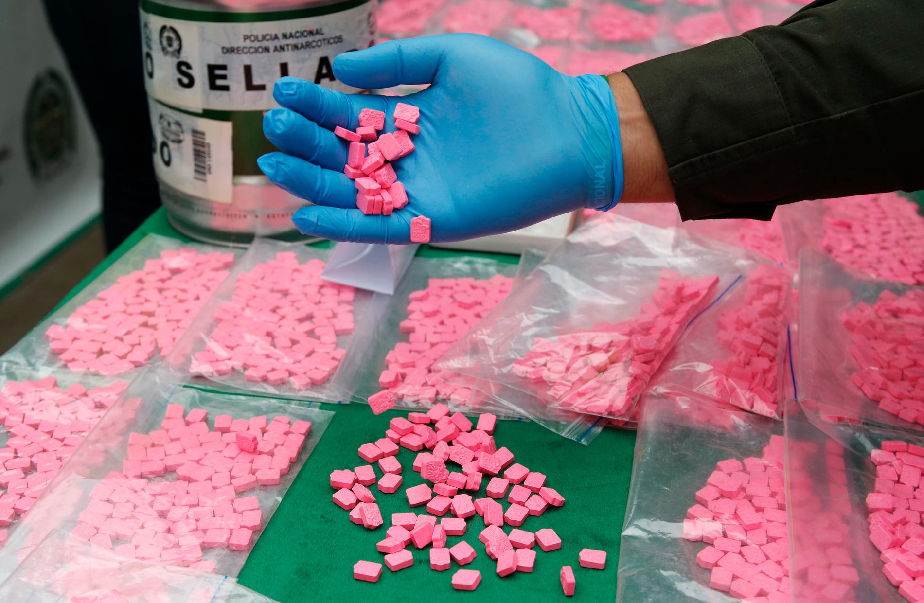 Polisen visar upp MDMA-tabletter från ett tidigare drogtillslag i Colombia. Arkivbild.