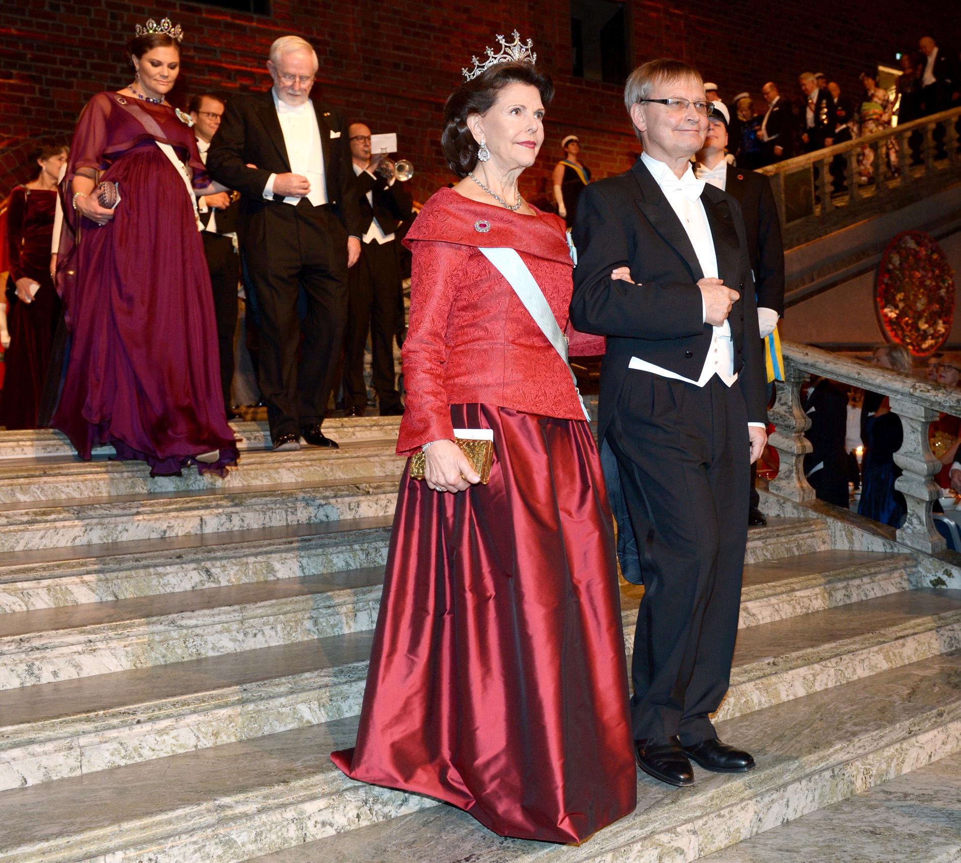 Drottning Silvia och Carl-Henrik Heldin, ordförande för Nobelkommittén, anländer till Blå hallen inför Nobelbanketten i Stadshuset i Stockholm på torsdagen.