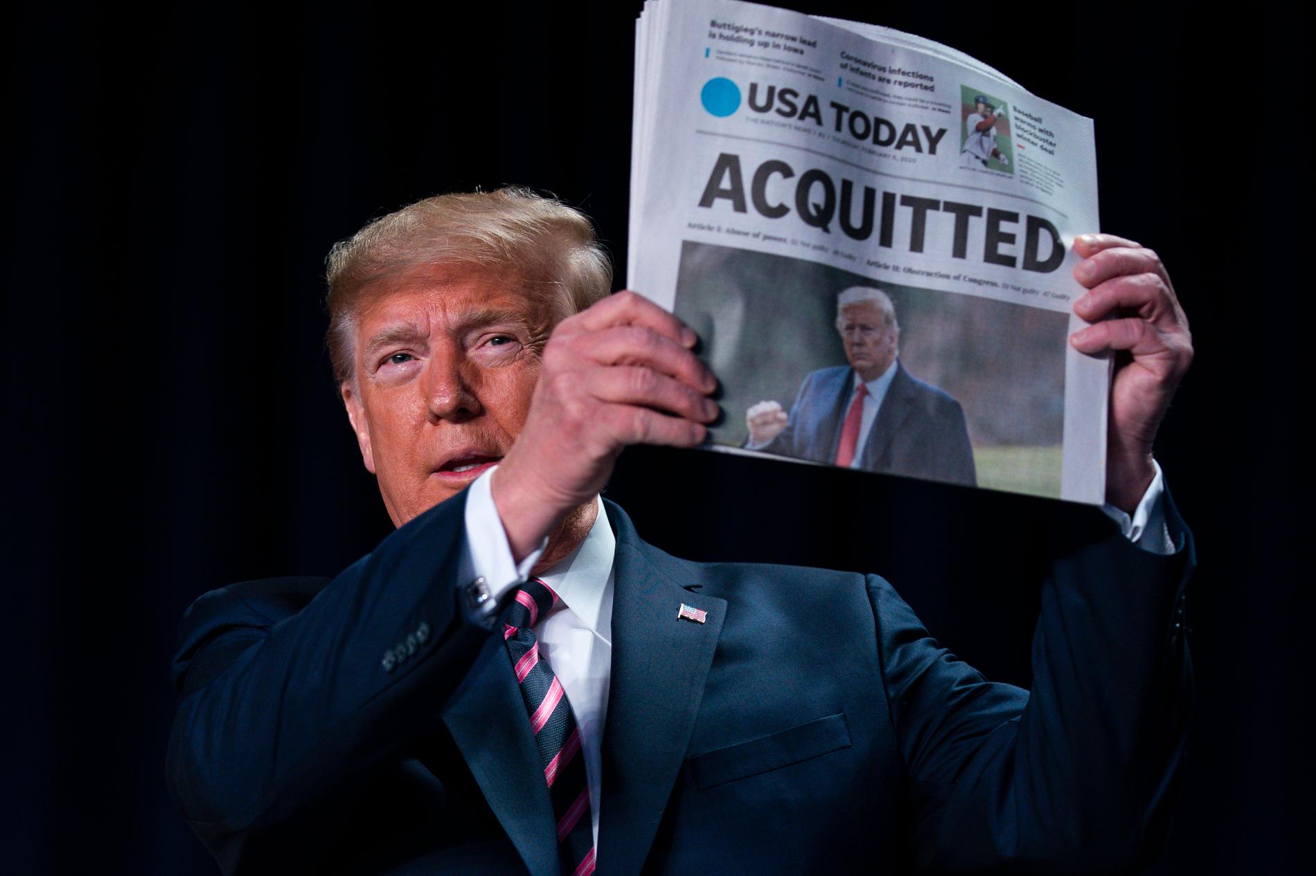 USA:s president håller upp en tidning med rubriken: "Frikänd".