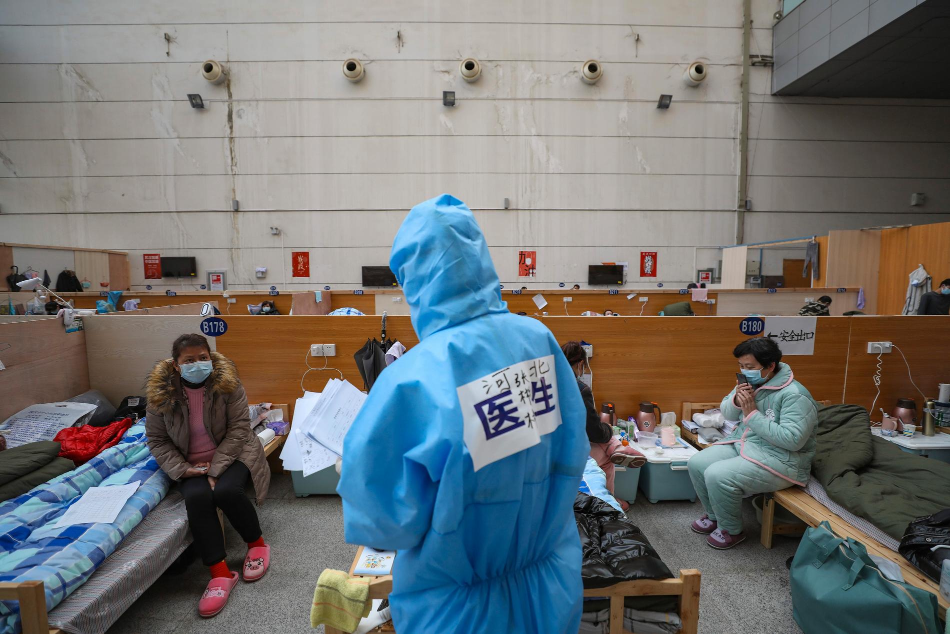En läkare kontrollerar patienter på ett provisoriskt sjukhus i Wuhan i Kina. Bild tagen 21 februari.