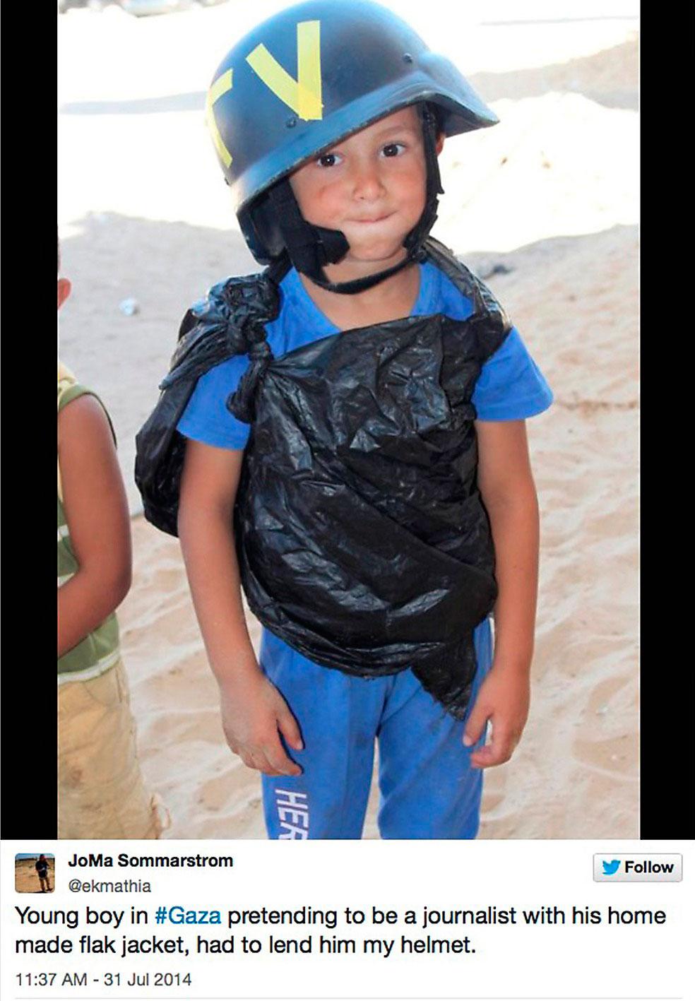 En pojke i Gaza som låtsas vara journalist och har fått låna en svensk journalists hjälm.