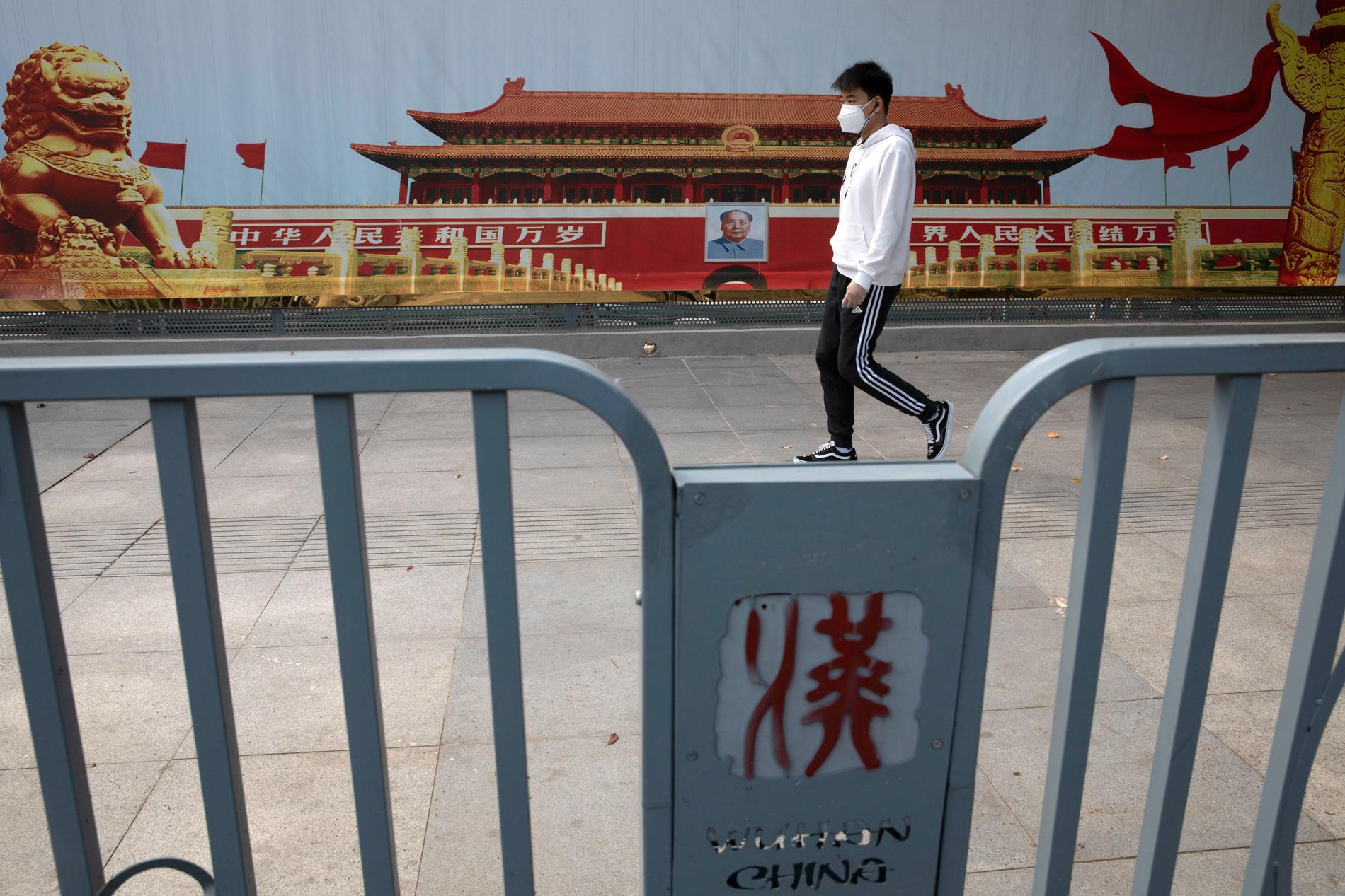 En Wuhan-bo går förbi propaganda med bilder på Himmelska fridens torg i Peking.