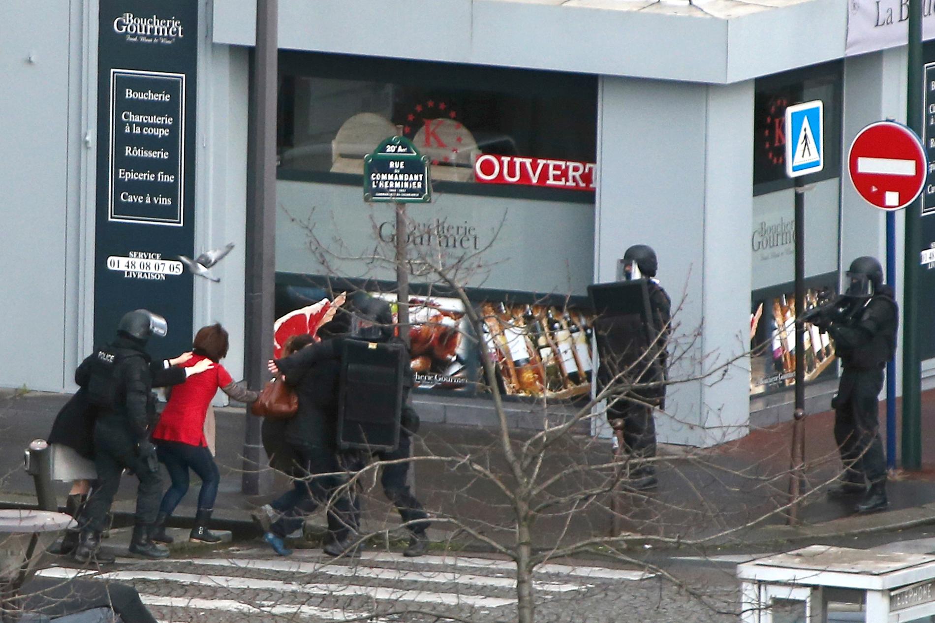 Civila evakueras kring butikdör gisslan befinner sig