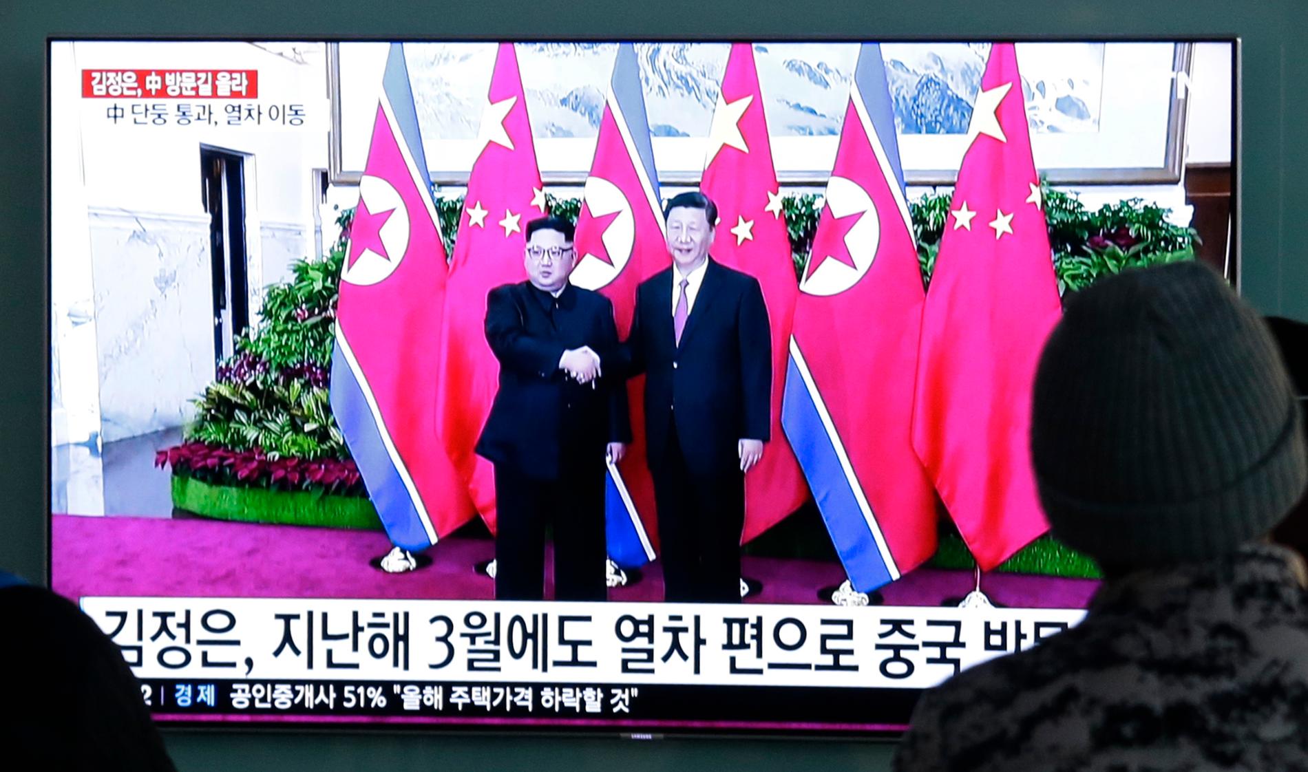 Arkivbilder från ett tidigare möte mellan Nordkoreas ledare Kim Jong-Un och Kinas president Xi Jingping visas på tv i Seoul i samband med Kim Jong-Uns resa till Peking.
