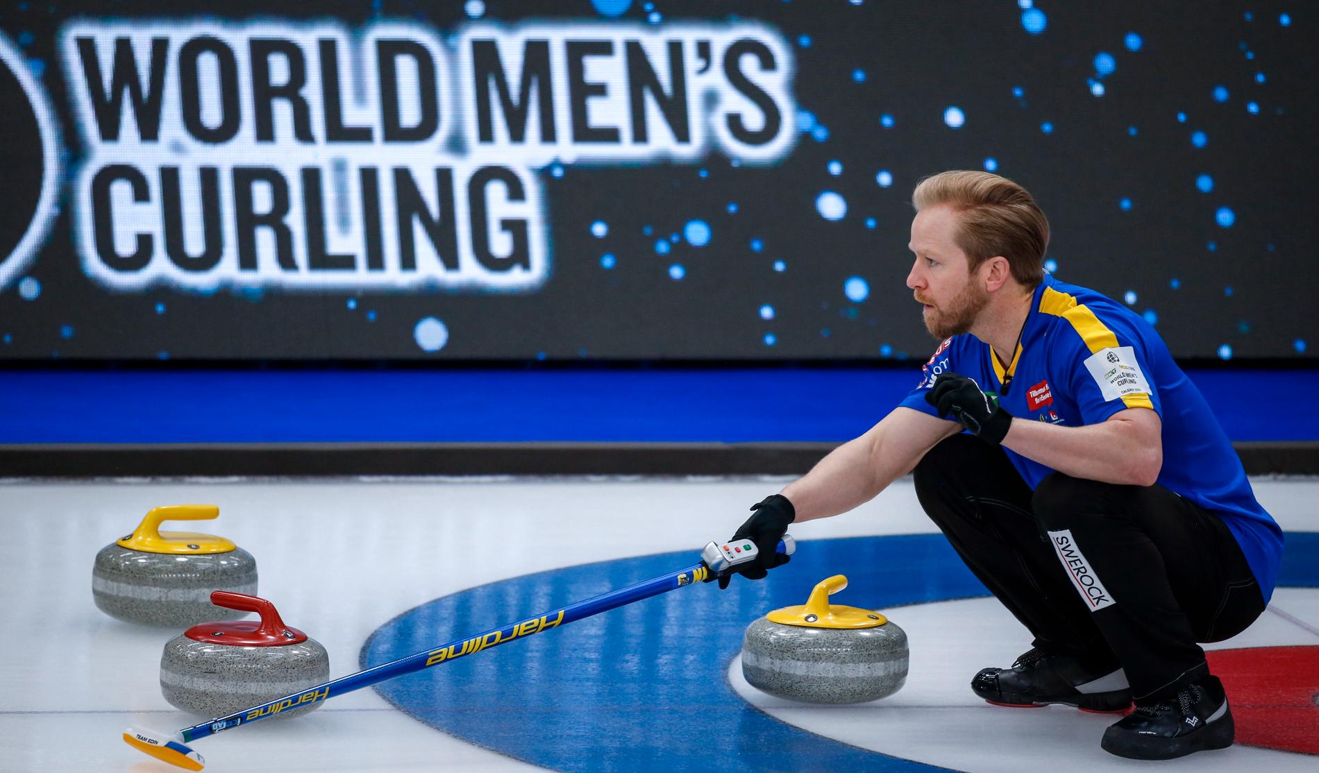 Sveriges skipper Niklas Edin visar hur lagkamraterna ska slå en sten under curling-VM.