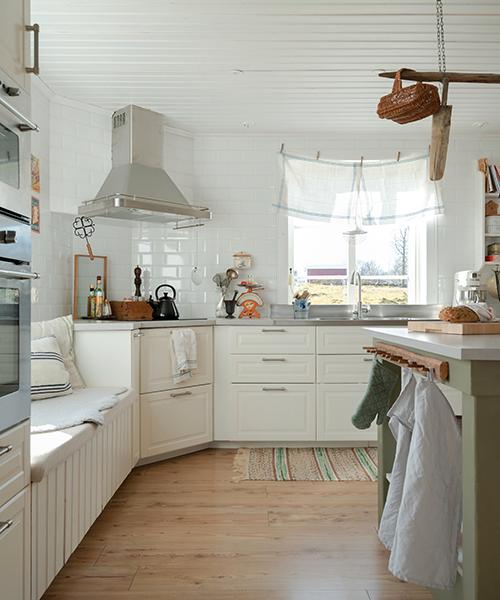 En rolig och annorlunda detalj i familjens kök är kökshanddukarna som används som gardin. Köksinredning, Ikea. Knopplisten på köksön är köpt second hand.
