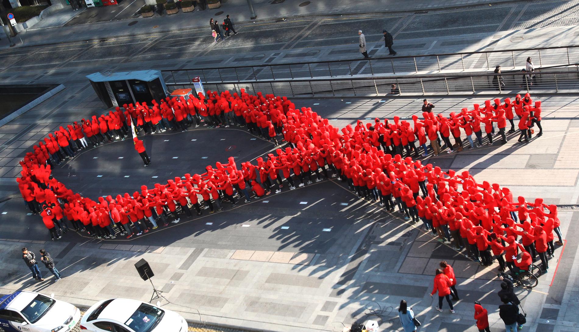 Elever i Sydkorea formar det röda bandet, symbolen för medvetenhet och stöd till dem som smittats av hiv. Arkivbild.