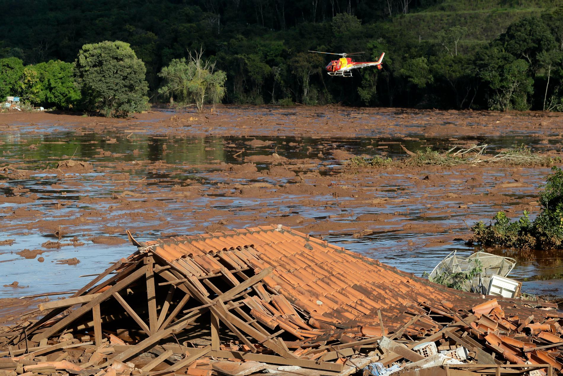 Helikopterburna räddningsarbetare letar offer efter dammkollapsen.