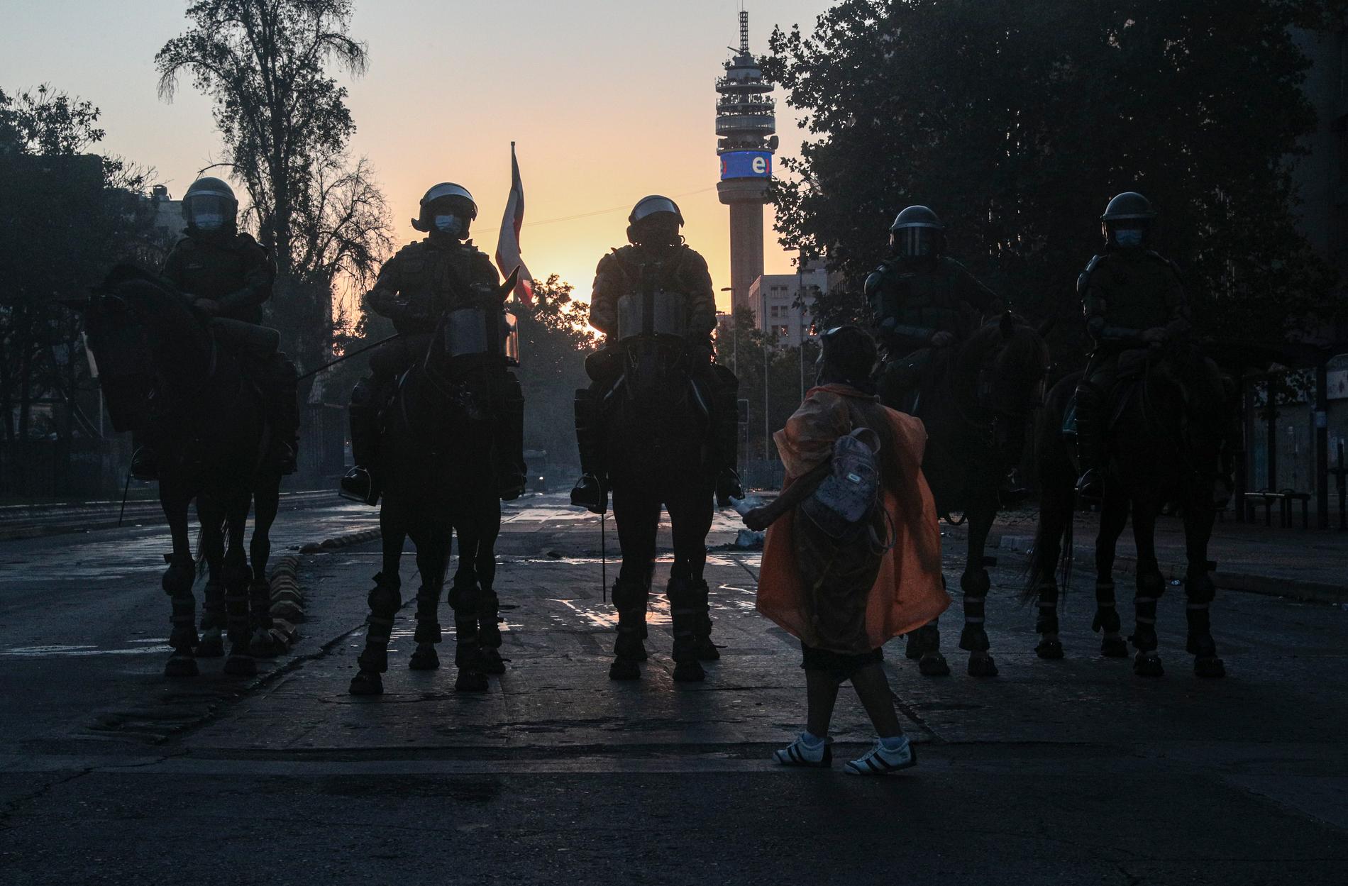 En kvinna diskuterar med ridande poliser i Chiles huvudstad Santiago, i samband med protester i början av februari. Arkivbild.