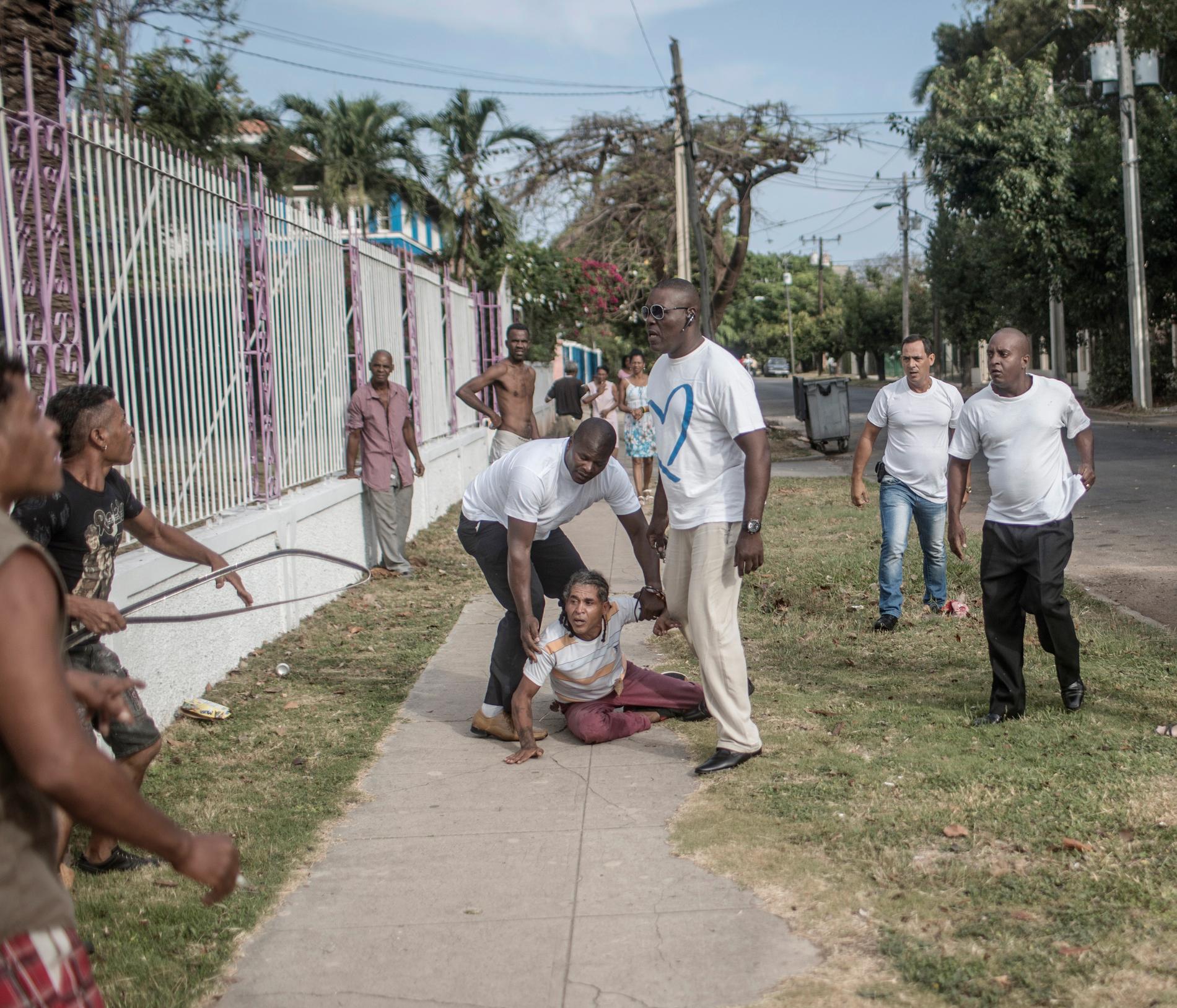 Årets fotograf 2017, Magnus Wennman. Samtidigt som Barack Obama anländer till Kuba slår civilklädda säkerhetspoliser till mot en grupp män som demonstrerar på gatan. Blixtsnabbt förs en av demonstranterna in i en väntande bil och körs iväg.