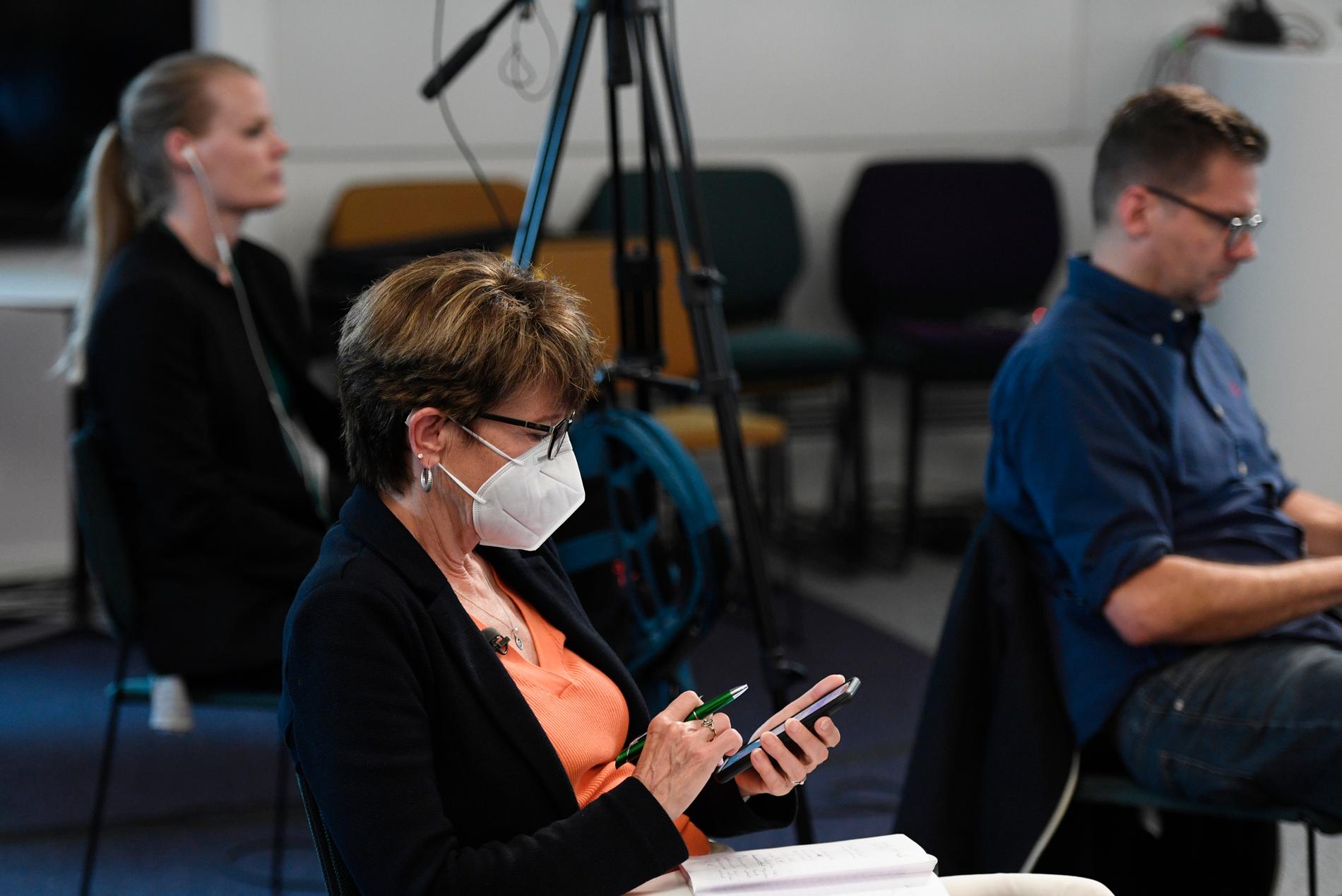 En reporter med munskydd under en av Folkhälsomyndighetens pressträffar om covid-19.