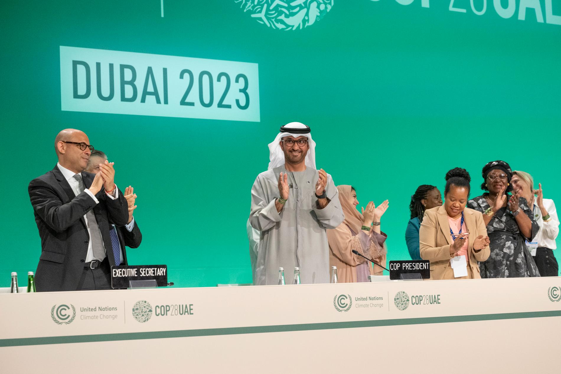 FN:s klimatchef Simon Stiel och Sultan al-Jaber, chef för COP28, klappar händerna efter att avtalet är klart på COP28.