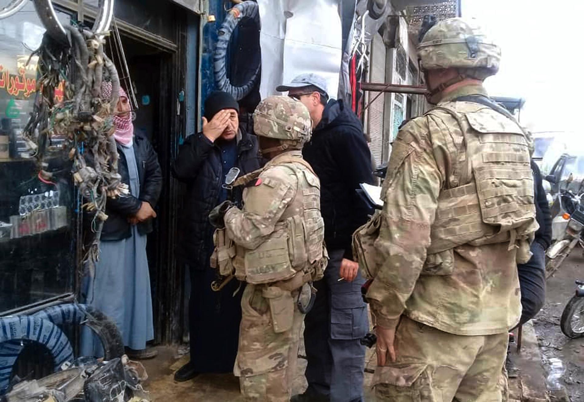 USA:s trupper ska lämna Syrien. Här är amerikanska soldater i samspråk med invånare i staden Manbij på söndagen.