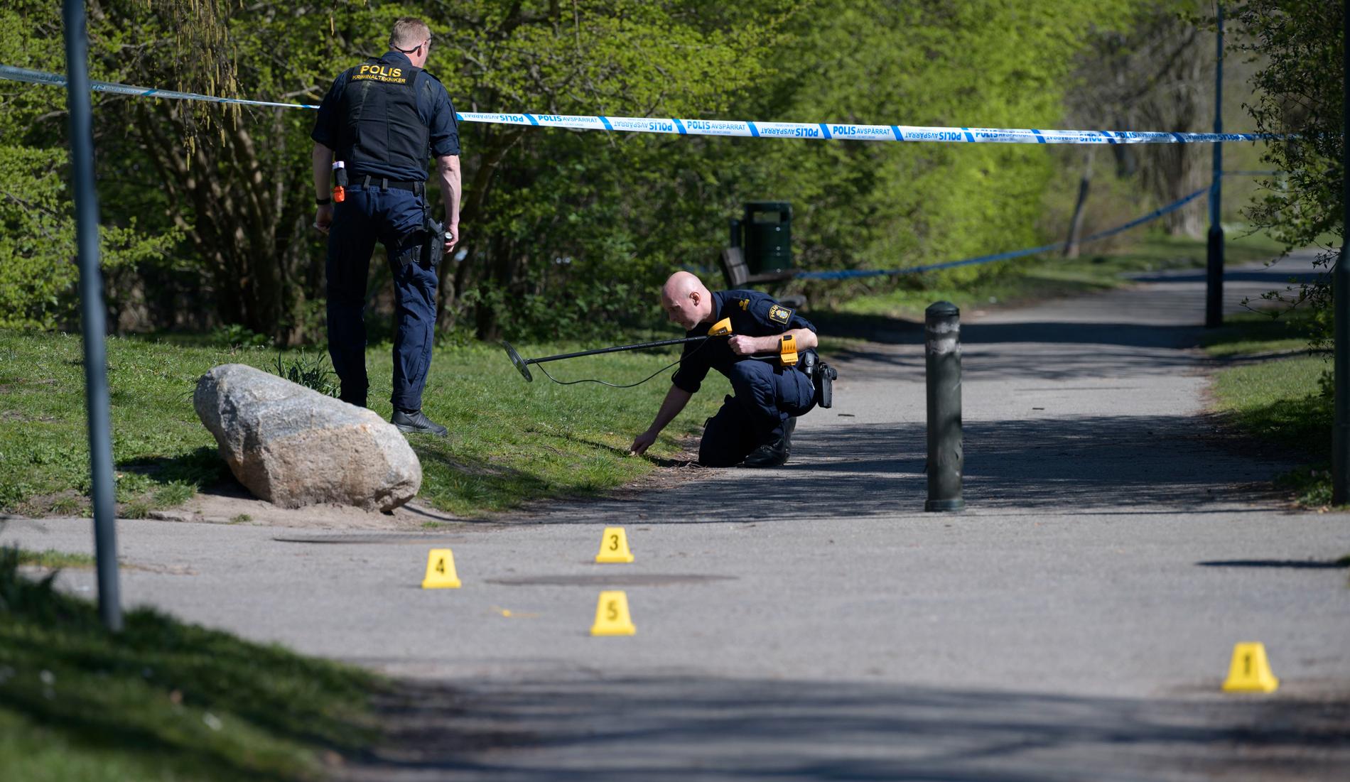 Polisens kriminaltekniker undersöker ett avspärrat område i Malmö på långfredagen efter det att polis skjutit en knivbeväpnad man i benet.
