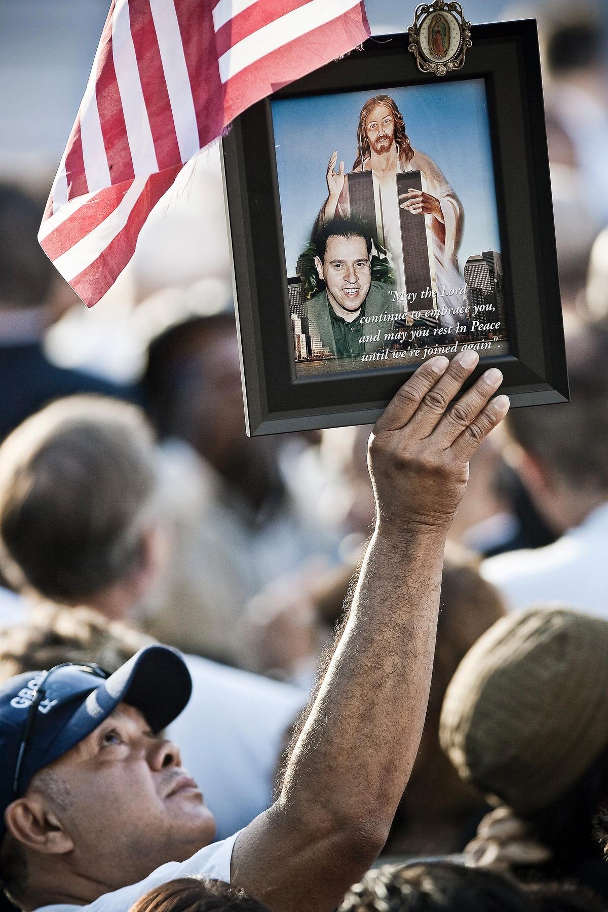 MINNE Mario Montoya håller upp ett foto av sin bäste vän Harry Ramos som dog i terrordådet.