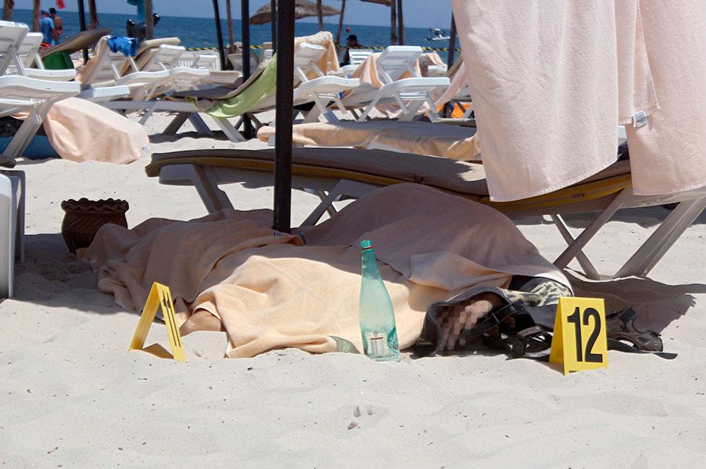En dödad turist ligger under ett skynke på stranden i Sousse.