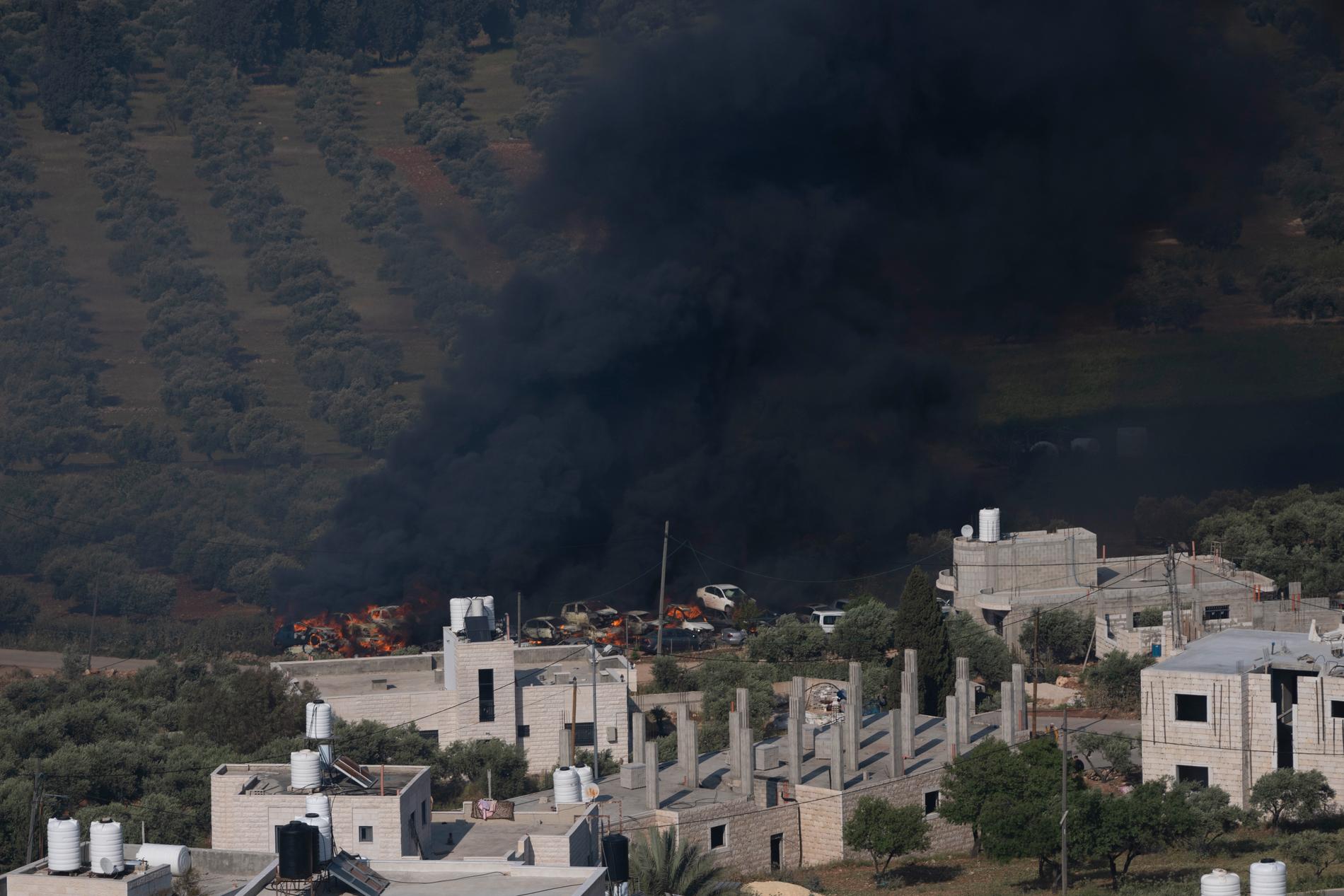 Rök stiger över byn al-Mughayyir på Västbanken efter att israeliska bosättare tänt eld på palestinska invånares fastigheter. Bild från 13 april.