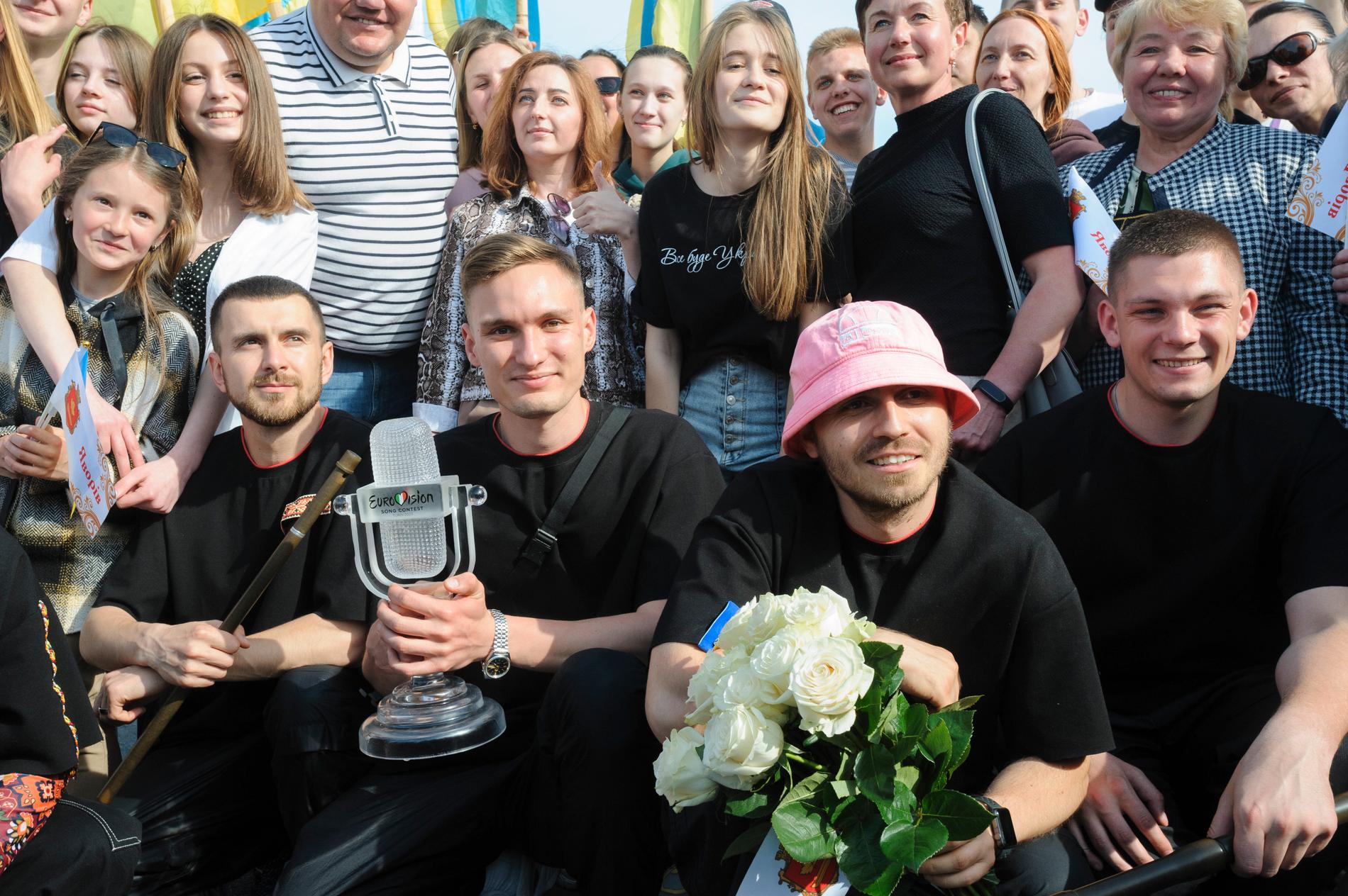 Oleh Psiuk i sin rosa mössa och resten av medlemmarna i Kalush Orchestra poserar med fans. Bandet auktionerat ut statyetten och mössan. Arkivbild.