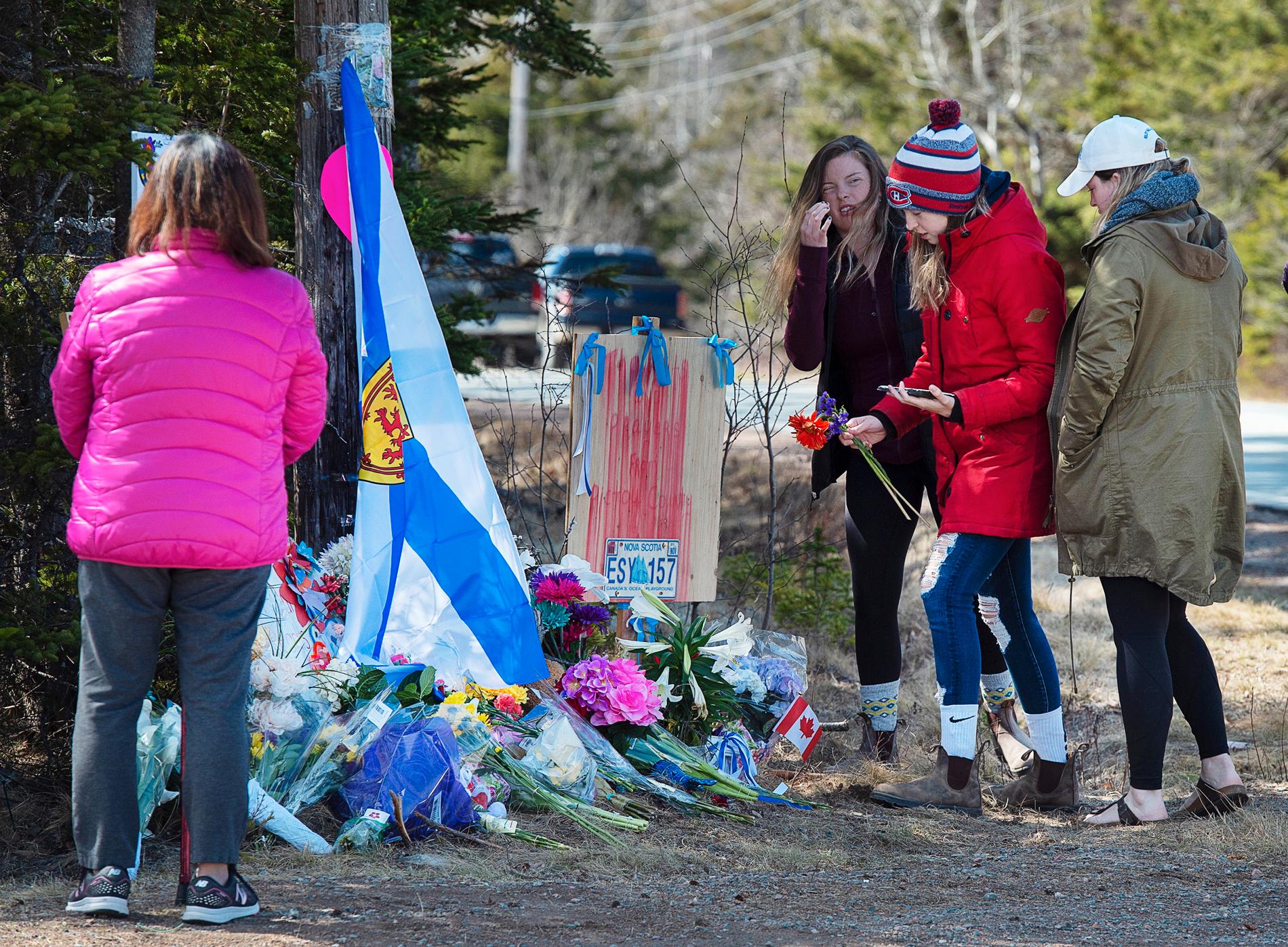 Människor hedrar offren vid en spontan minnesplats i Portapique i Nova Scotia.