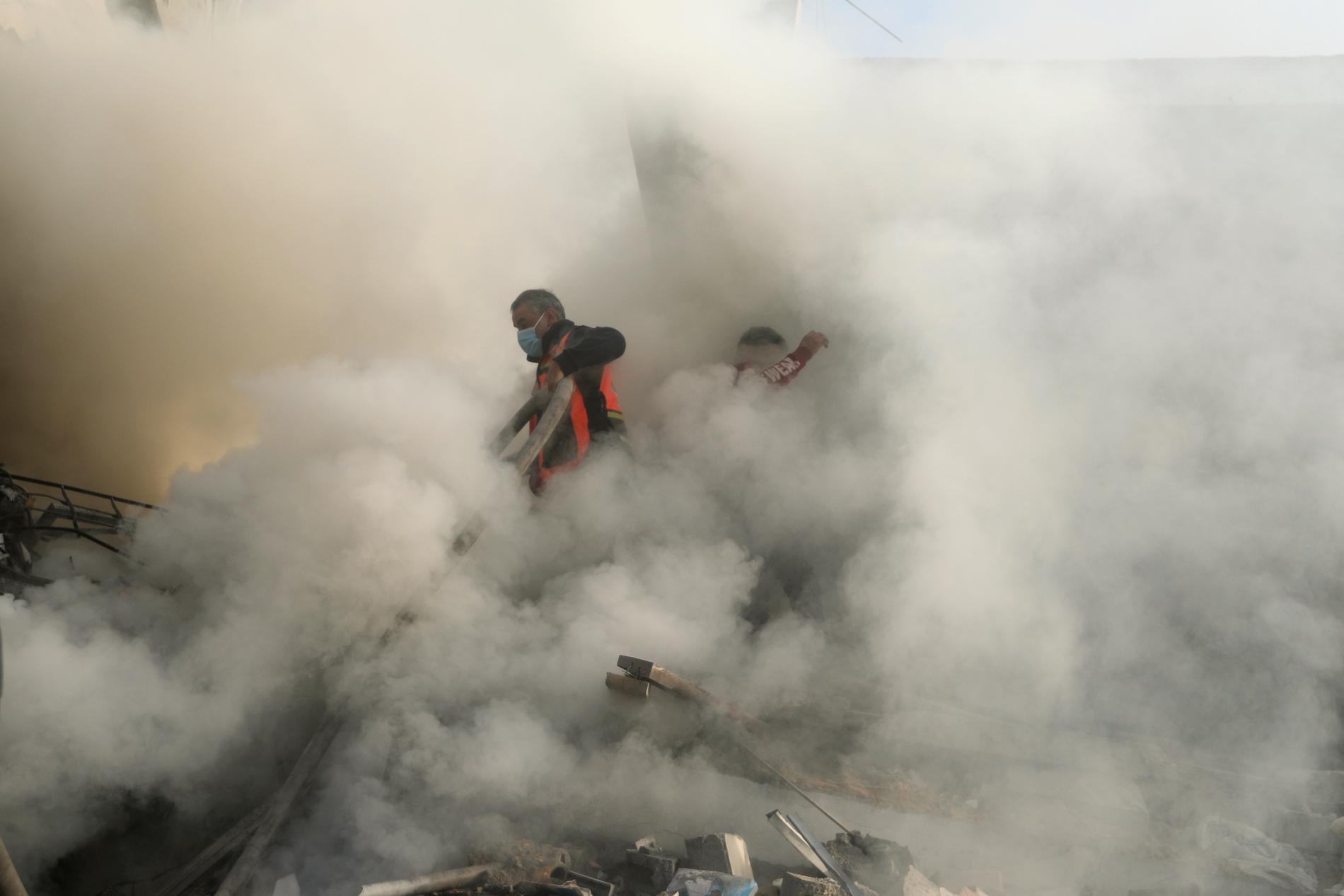 Brandman kämpar mot röken i flyktinglägret i Khan Younis, södra Gazaremsan. 