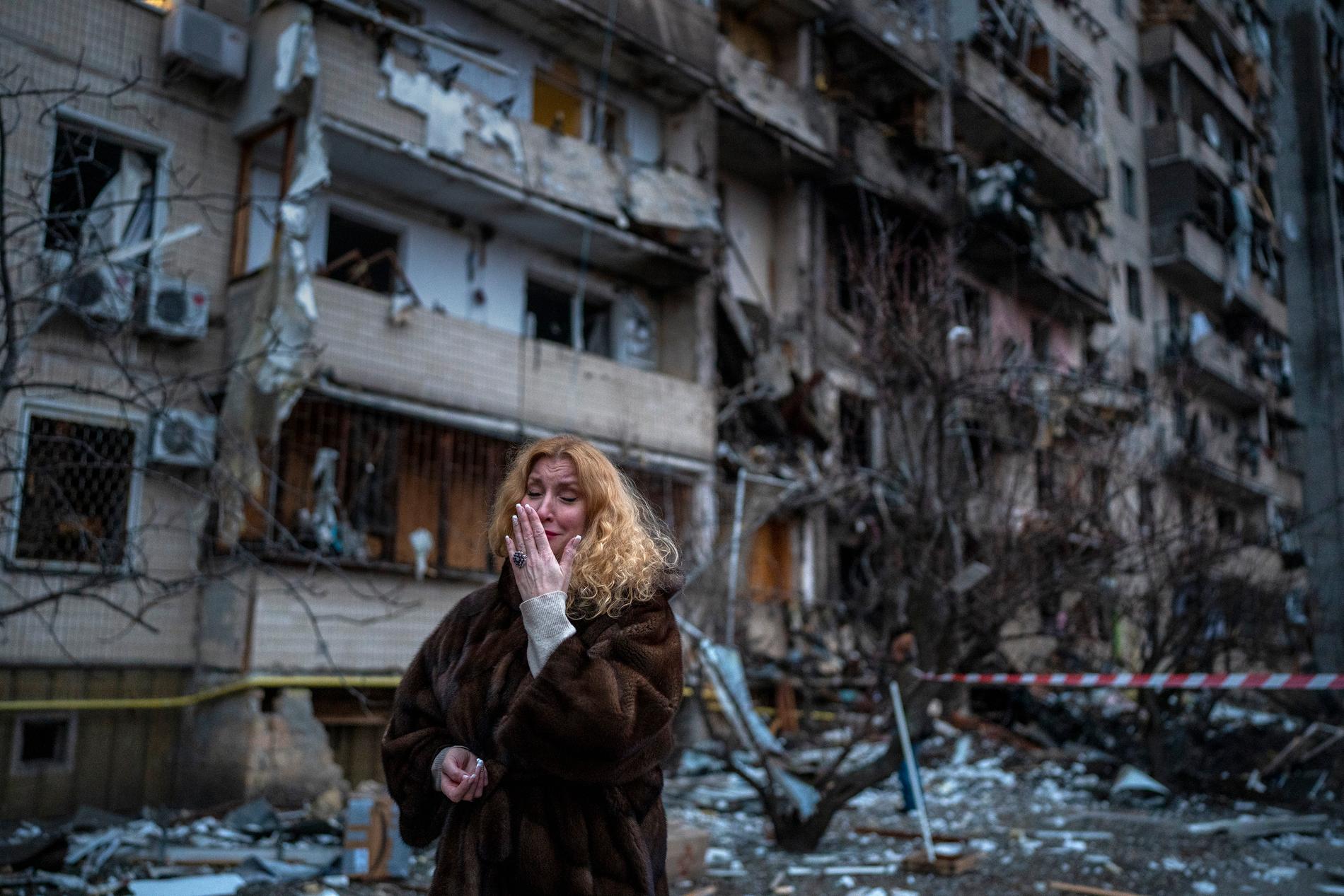 Natali Sevriukova står bredvid sitt hus i Kiev som blivit träffat av raketer under natten. 