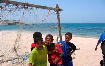 Småkillarna i Mirbat kickar boll på stranden. En ihopsnickrad ställning med fisknät är en perfekt målbur.