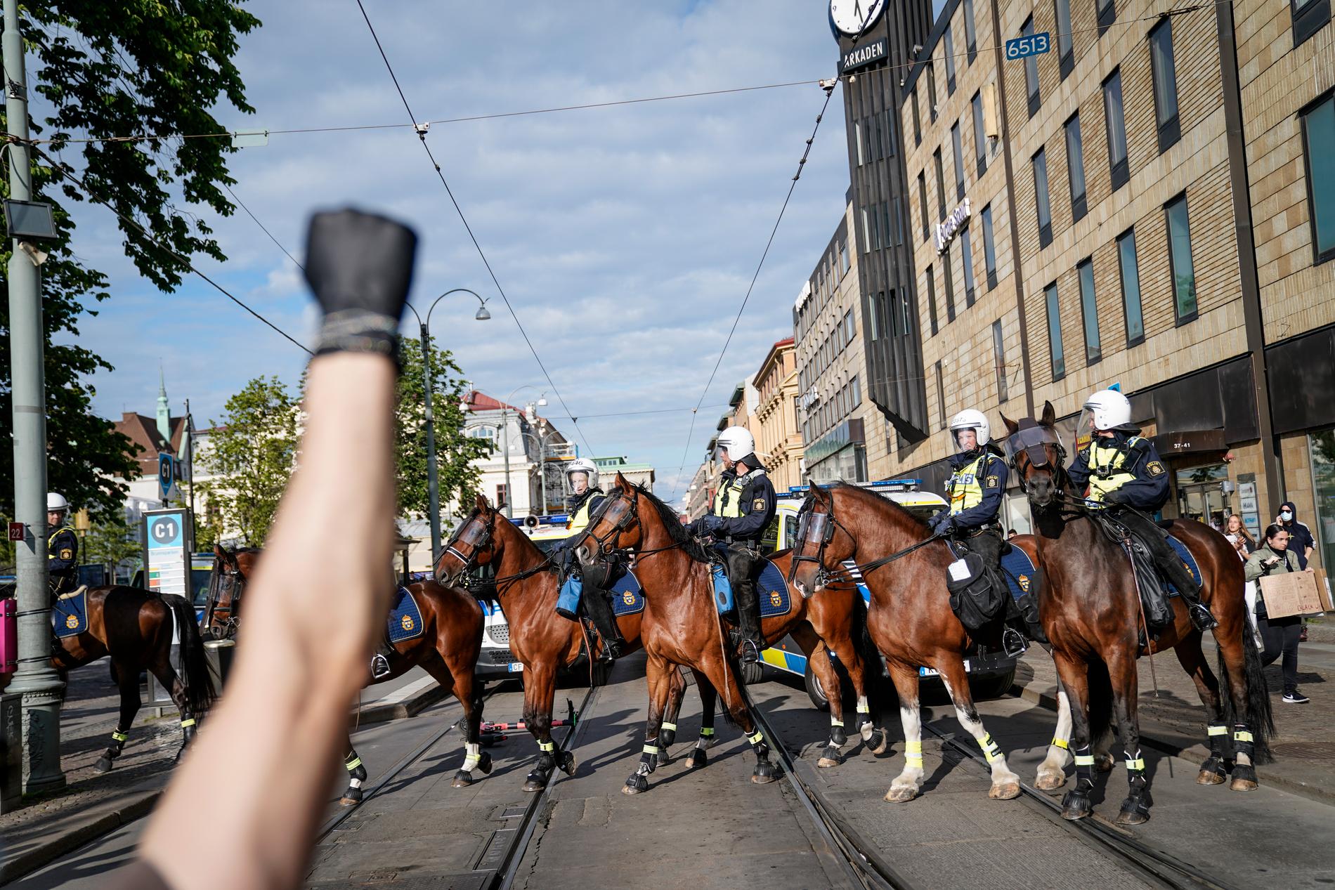 Knuten näve med svart handske framför ridande polis som skingrar demonstranter i samband med Black lives matter-demonstrationen i Göteborg. Polisen upplöste demonstrationen, men många av de 2 000 deltagarna tågade ändå vidare genom staden, och oroligheter uppstod bland på flera platser. Arkivbild.