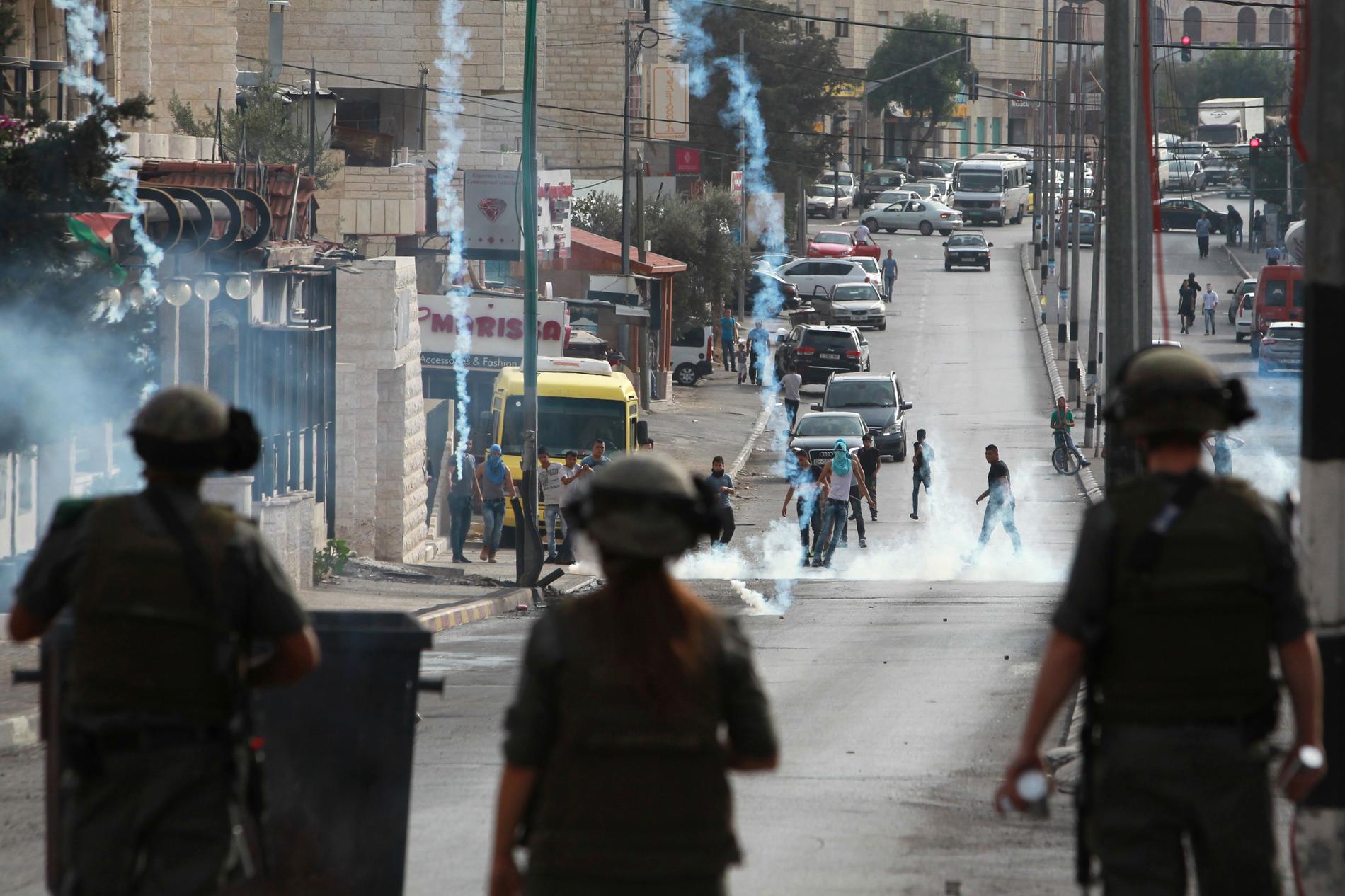 Israeliska styrkor skjuter tårgas mot palestinska demonstranter under måndagen.