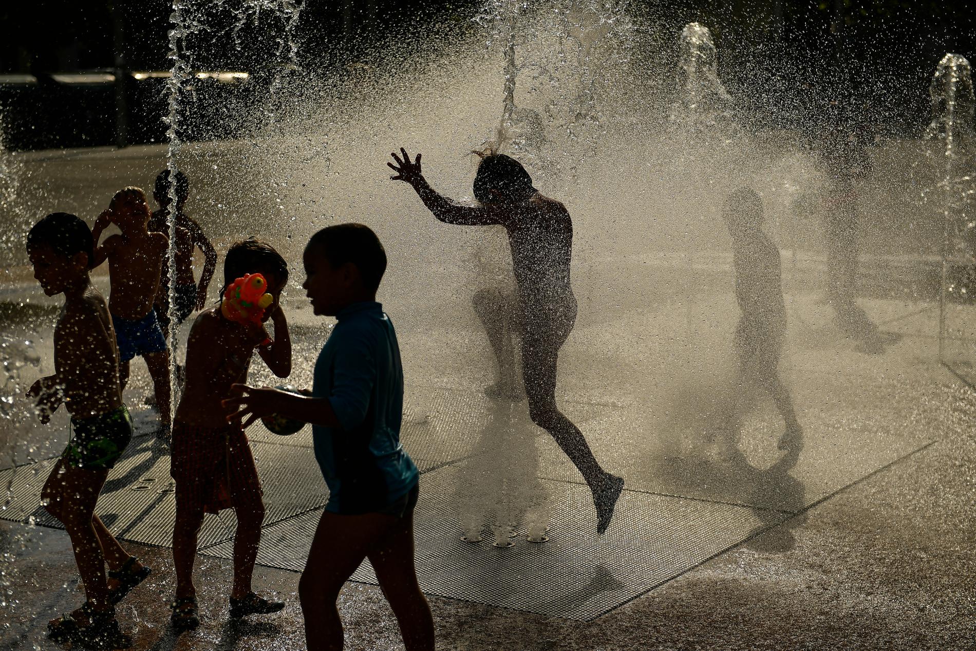 Barn som svalkar sig i en fontän i Pamplona i norra Spanien. I helgen väntas kvicksilvret klättra upp över 40 grader i landet.