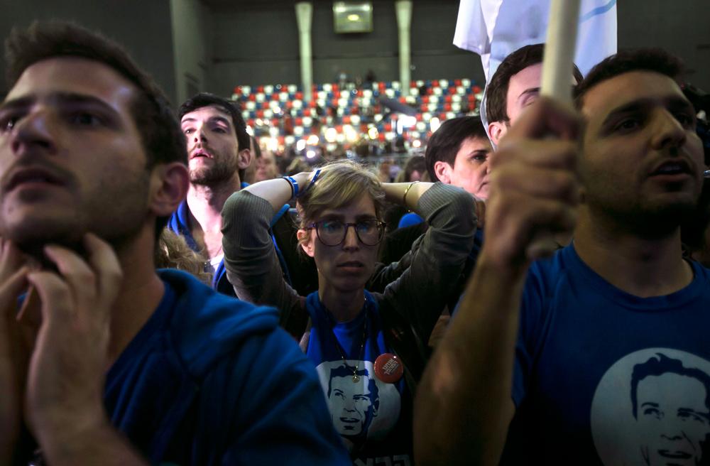 Isaac Herzogs anhängare reagerar när de får resultatet från vallokalsundersökningarna.