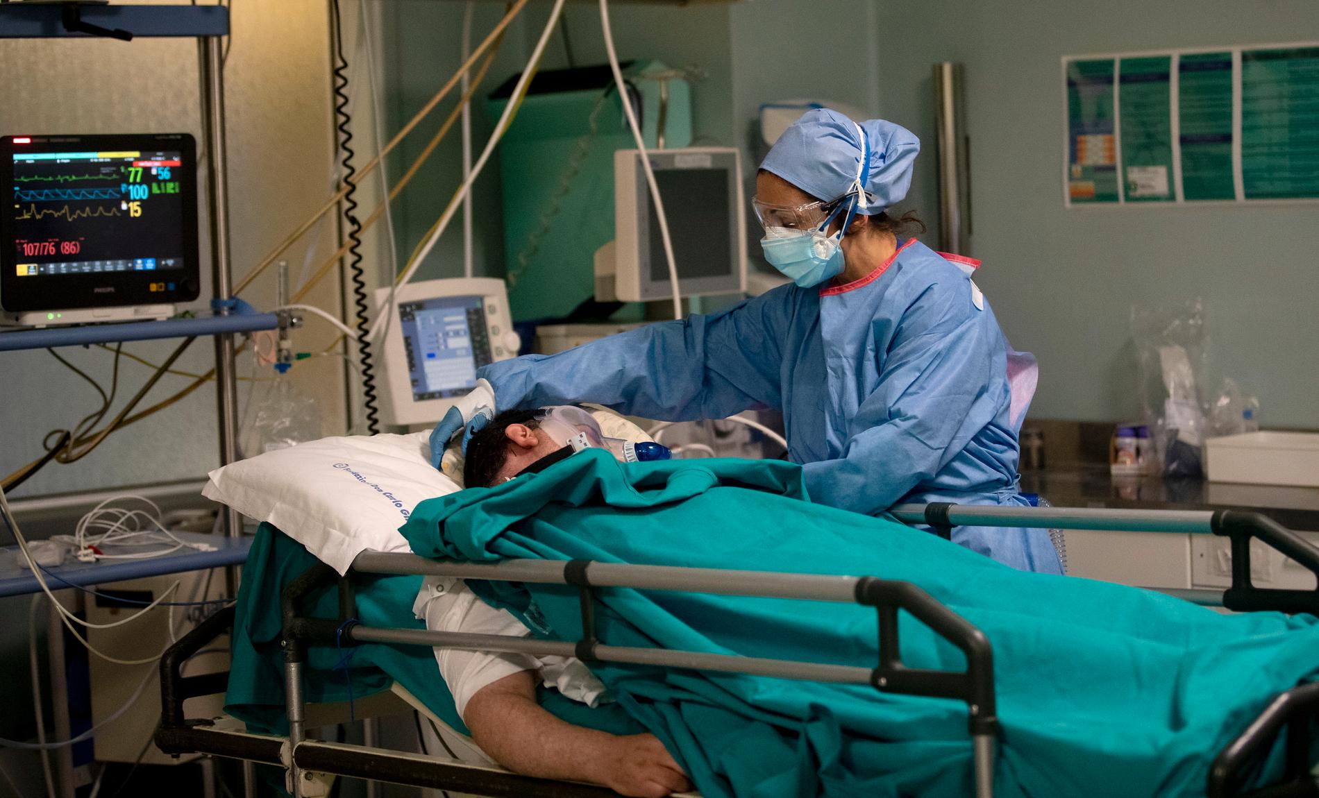 En sjuksköterska tar hand om en patient vid en akutmottagning för covid-19-patienter i Milano. Arkivbild.